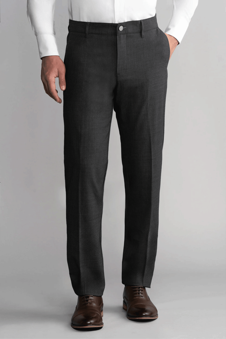 A man stands against a plain gray background wearing Twillory Hybrid Wool Pants in Grey Heather. His left hand is in his pocket, right arm by his side, and the image focuses on his lower torso and legs. A man stands against a plain gray background wearing Twillory Hybrid Wool Pants in Grey Heather. His left hand is in his pocket, right arm by his side, and the image focuses on his lower torso and legs.
