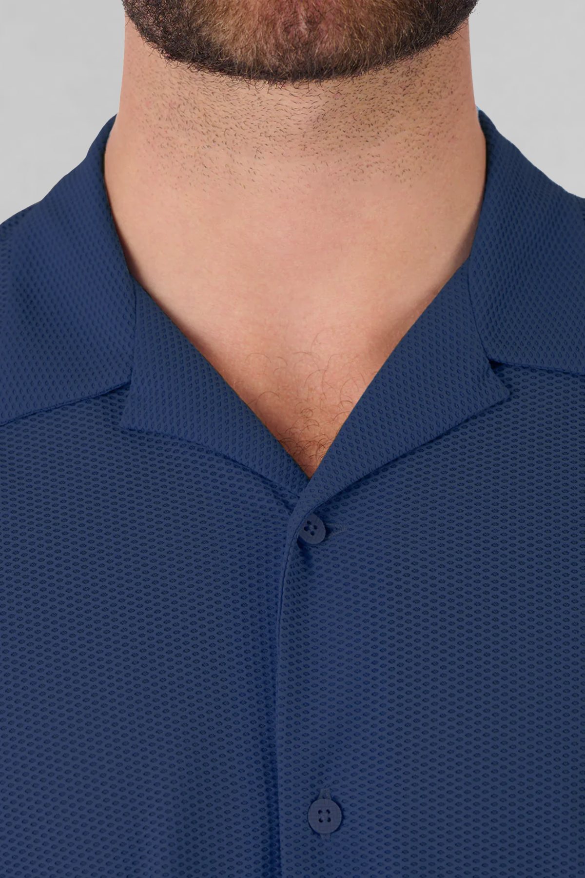A close-up of a man's neck and upper chest wearing the Twillory AIR Resort Shirt Solid in Navy, showcasing its cooling AIR fabric, buttoned collar, and premium texture. The image highlights the shirt’s collar details and quality material.