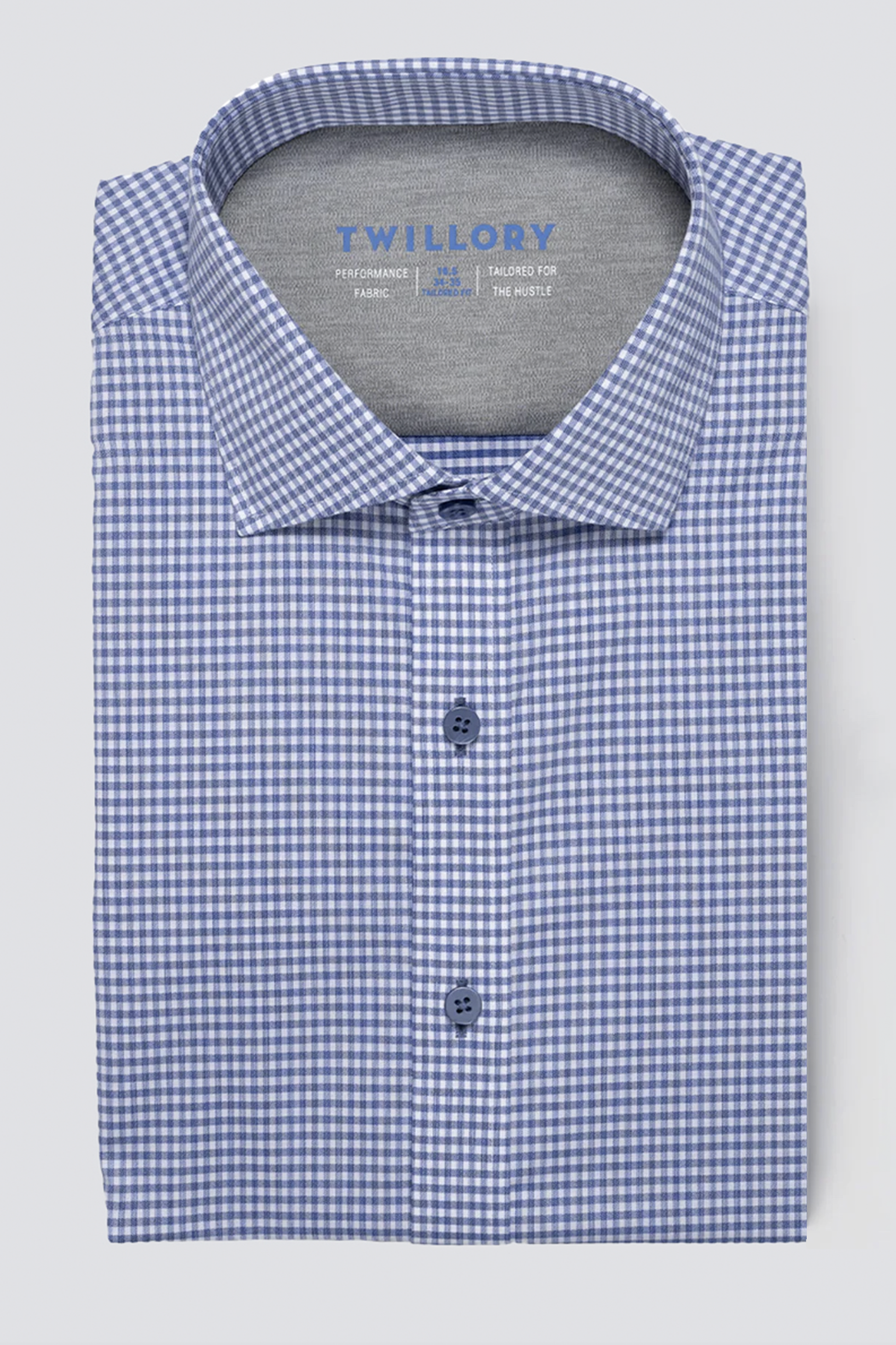 A folded Twillory Leader Check // Micro Blue Performance Shirt with a blue and white gingham pattern, structured collar, moisture-wicking fabric, and three visible blue buttons. "Twillory" is printed inside the collar on a light grey background.