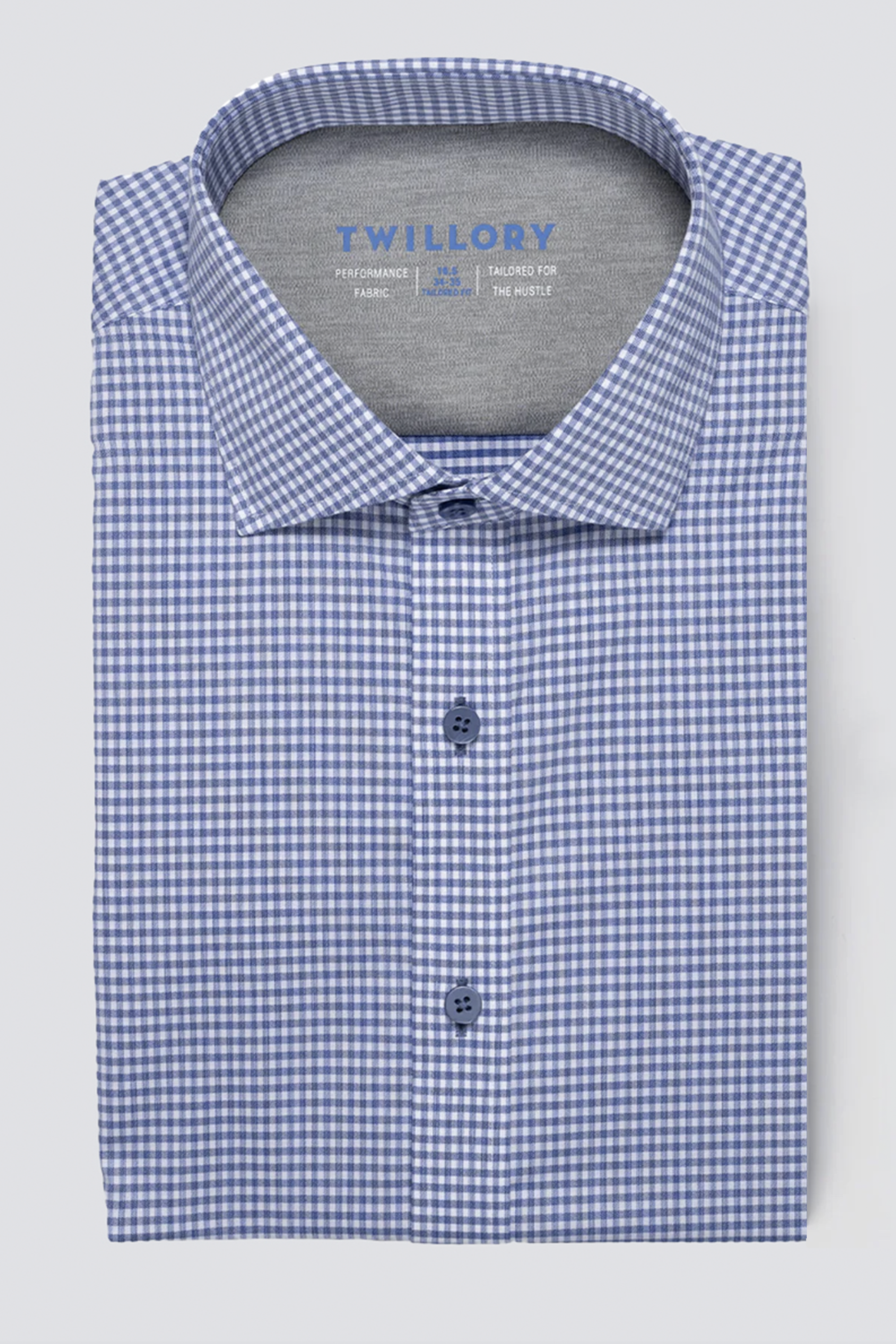 A folded Twillory Leader Check // Micro Blue Performance Shirt with a blue and white gingham pattern, structured collar, moisture-wicking fabric, and three visible blue buttons. "Twillory" is printed inside the collar on a light grey background.