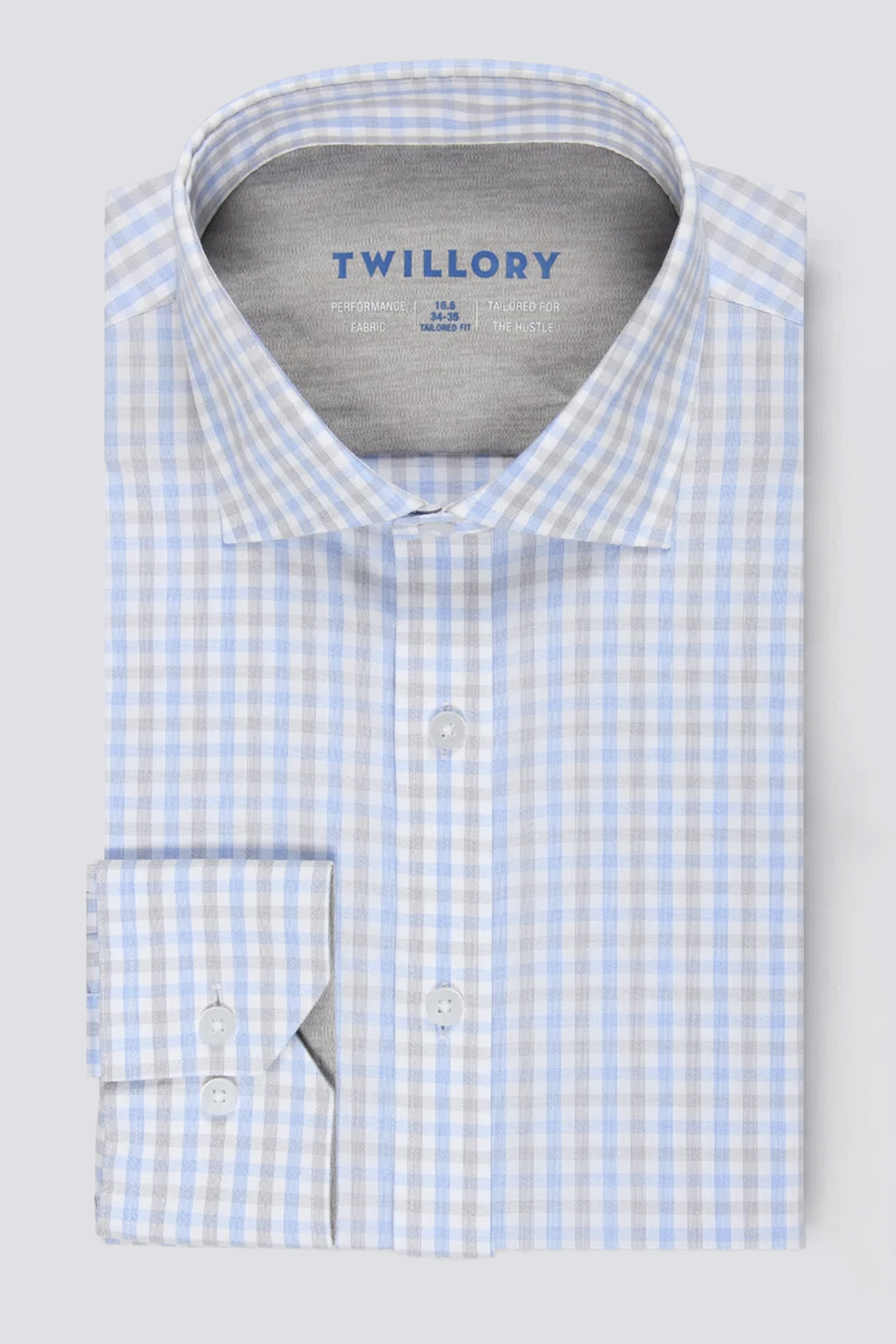 The Twillory Leader Check // Grey Blue Tattersall is a men’s long-sleeve dress shirt with a grey-blue check pattern, classic collar, white buttons, inner collar Twillory branding, and smooth moisture-wicking performance fabric.