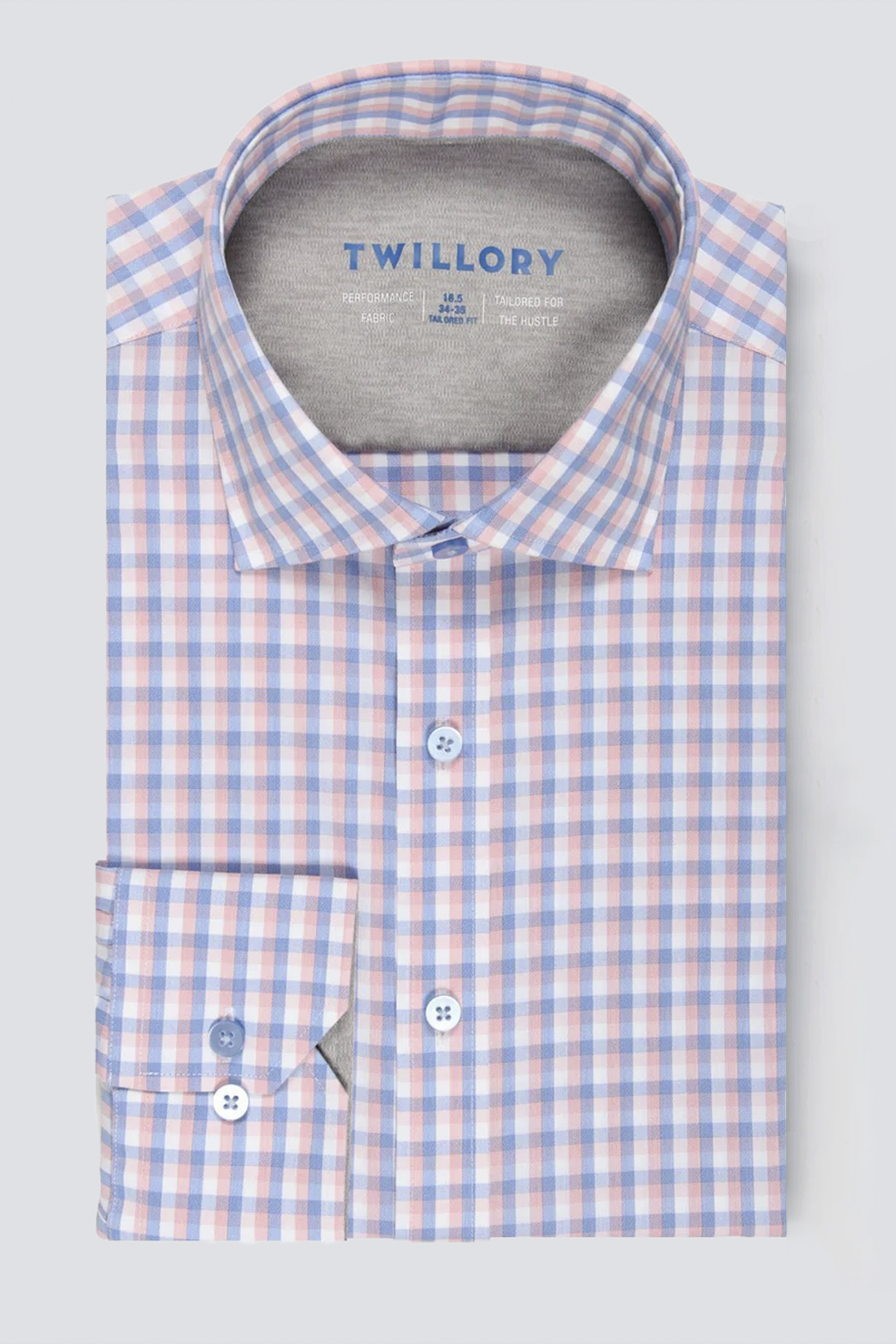 A neatly folded Twillory performance shirt, Leader Check // Orange Blue, features a blue, orange, and white checkered pattern, crisp collar with “Twillory” inside, two-button cuffs, and moisture-wicking fabric for all-day comfort.
