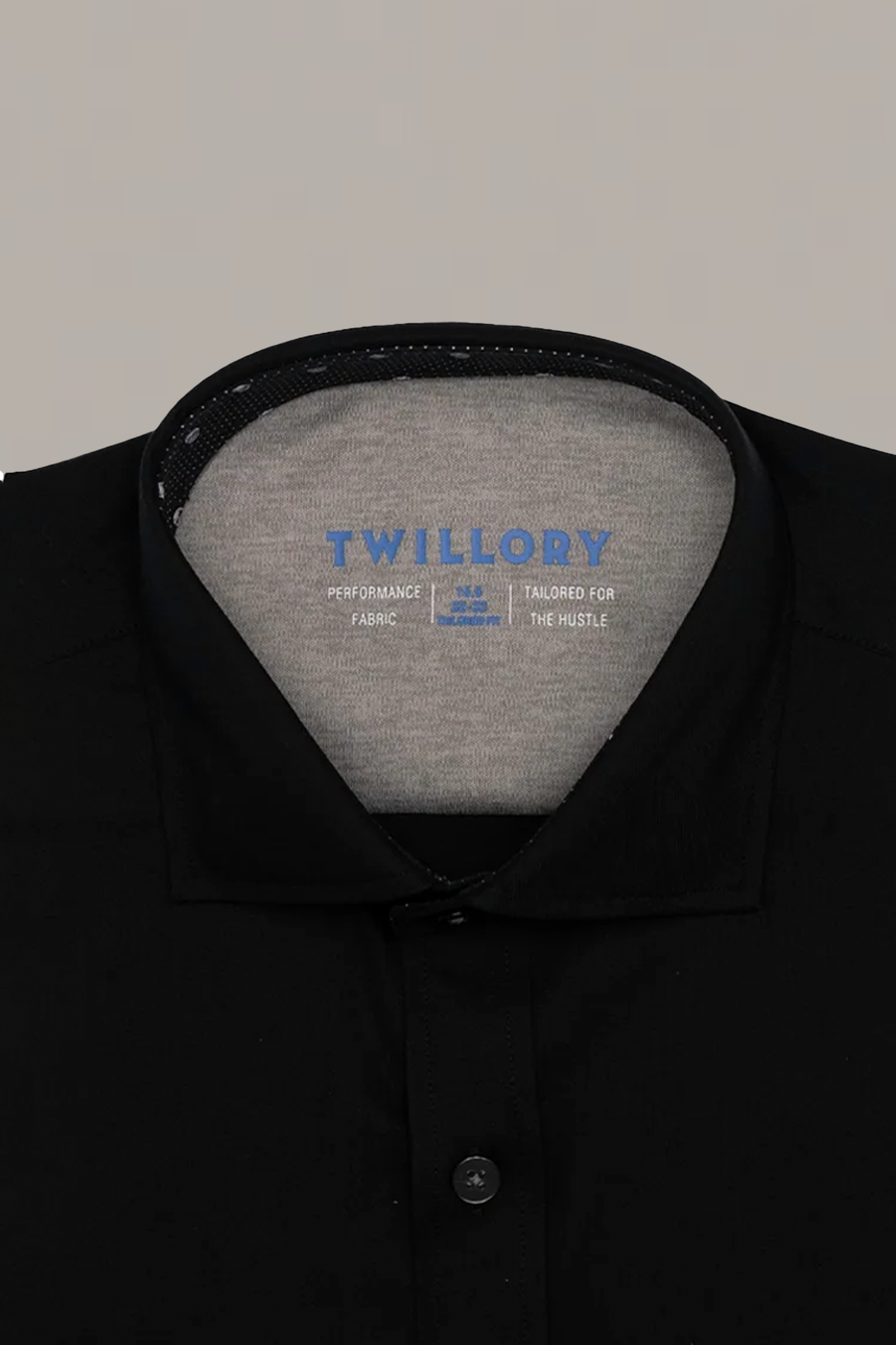 Close-up of the Twillory Leader Contrast // Black Skull Performance Shirt with the top button fastened. The inner label reads “Performance Fabric—Tailored for the Hustle.” Non-iron shirt shown on a plain light gray background.