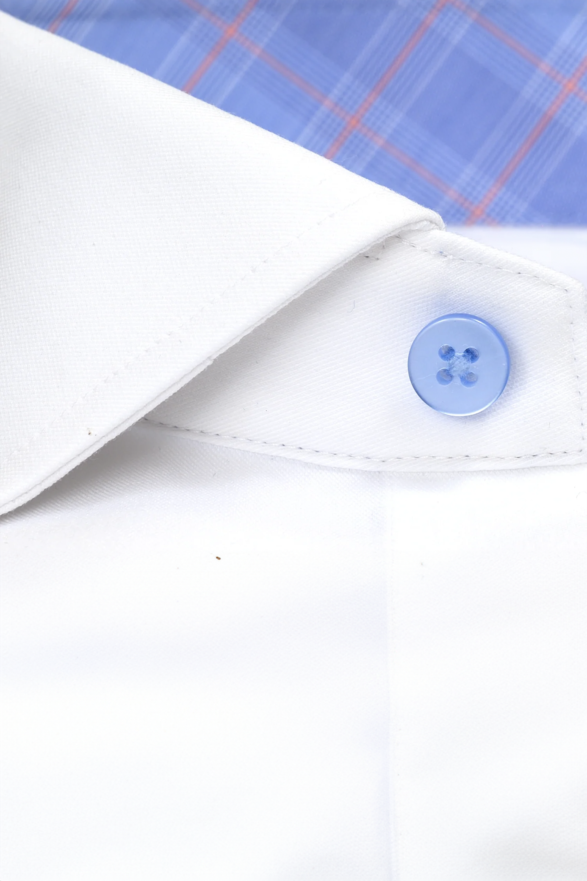Close-up of Twillory’s Leader Contrast // Blue Prince of Wales shirt: crisp white performance collar with blue button, set against blue plaid with red and white stripes. Showcases 4-way stretch texture and fine stitching.