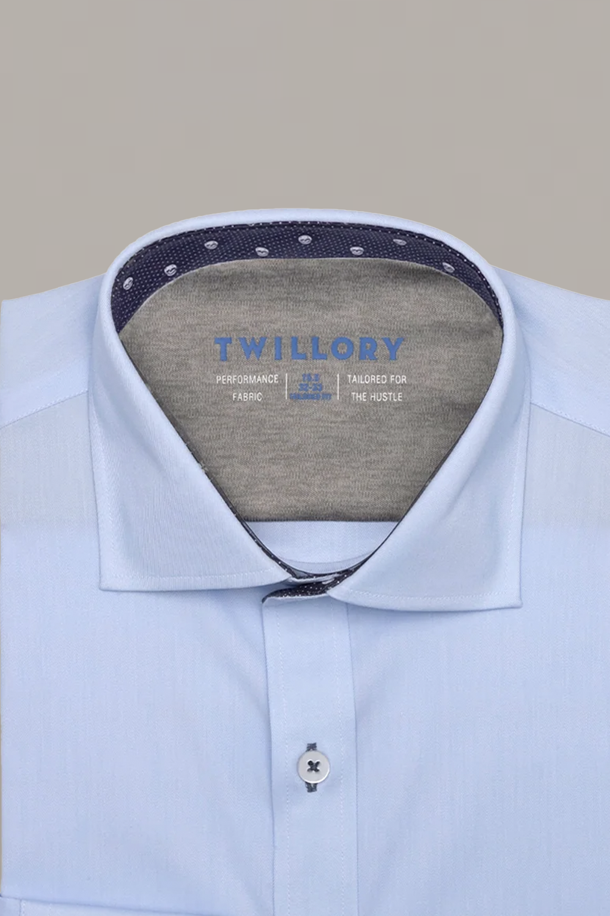 A neatly folded Leader Contrast // Blue Skull Performance Shirt by Twillory in light blue, featuring a structured collar with navy and white dot inner lining. Inside collar reads: "Twillory Performance Fabric Tailored for the Hustle" in blue and white.