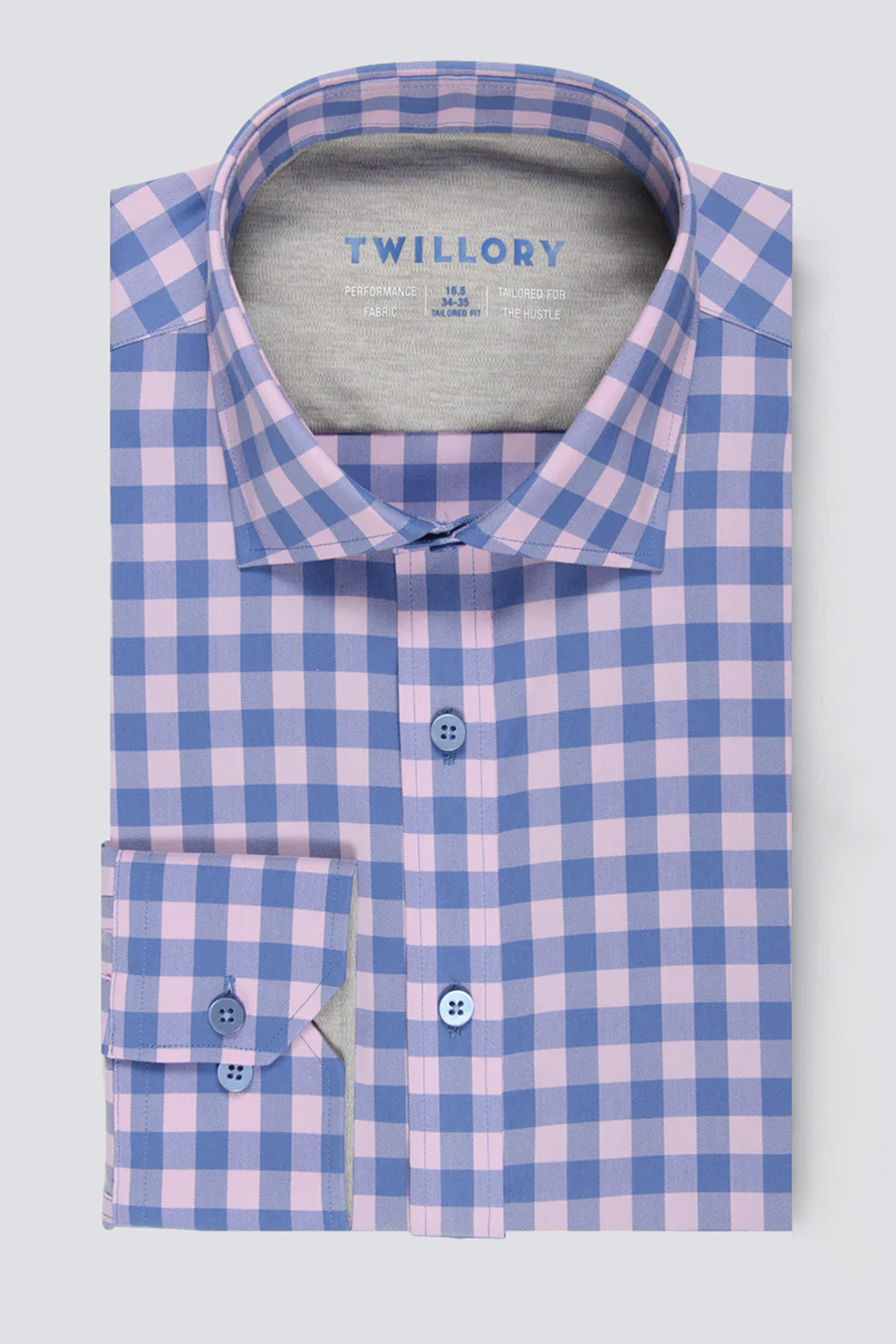 The Twillory Leader Gingham // Pink Blue is a men's dress shirt with a blue and pink check pattern, 4-way stretch, classic collar, blue front buttons, buttoned cuffs, and an inside label with care instructions.