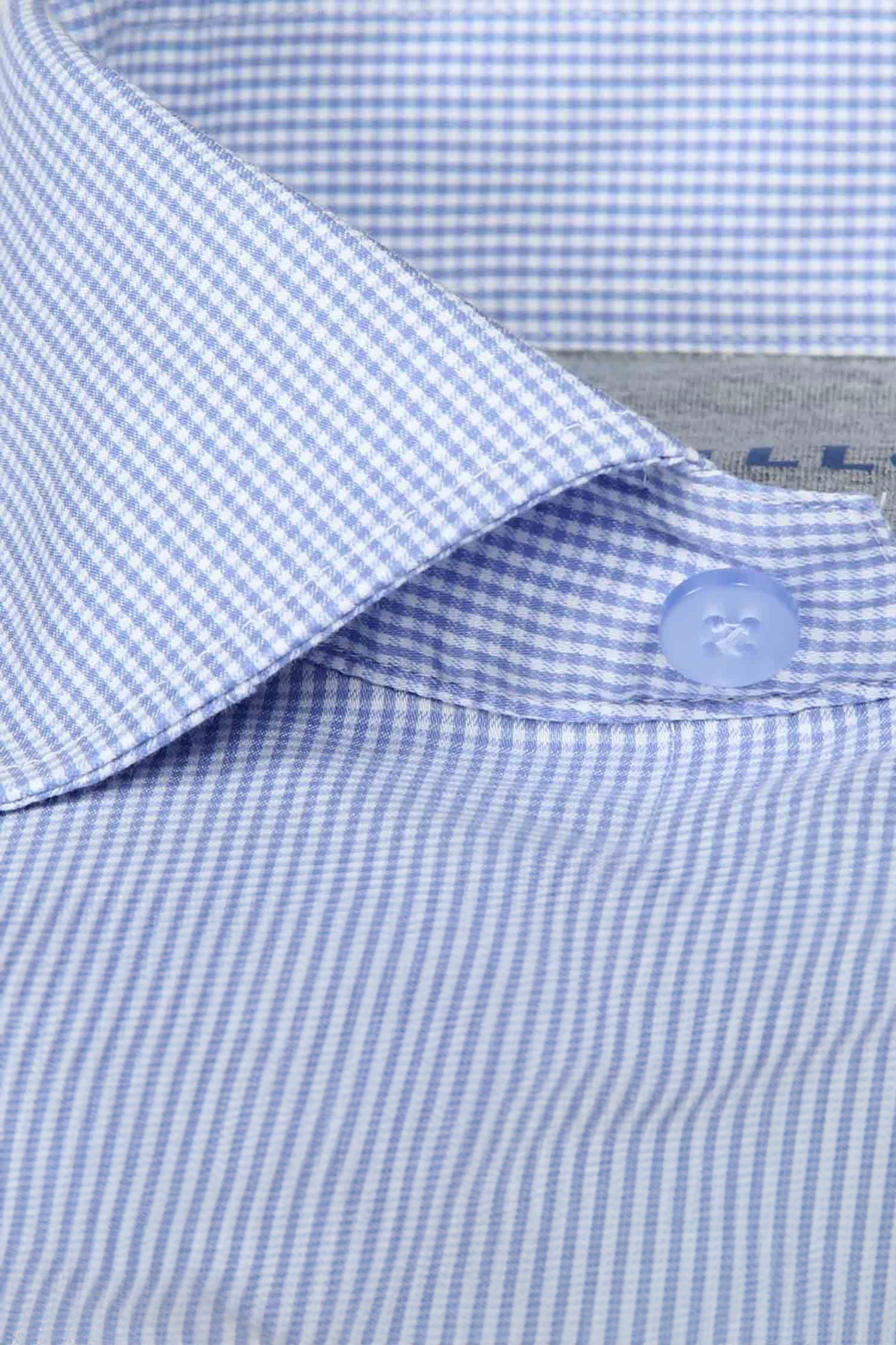 Close-up of a Leader Houndstooth // Micro Blue Performance Shirt collar by Twillory, featuring light blue and white micro checks, a crisp tailored design, neat stitching, and 4-way stretch comfort.