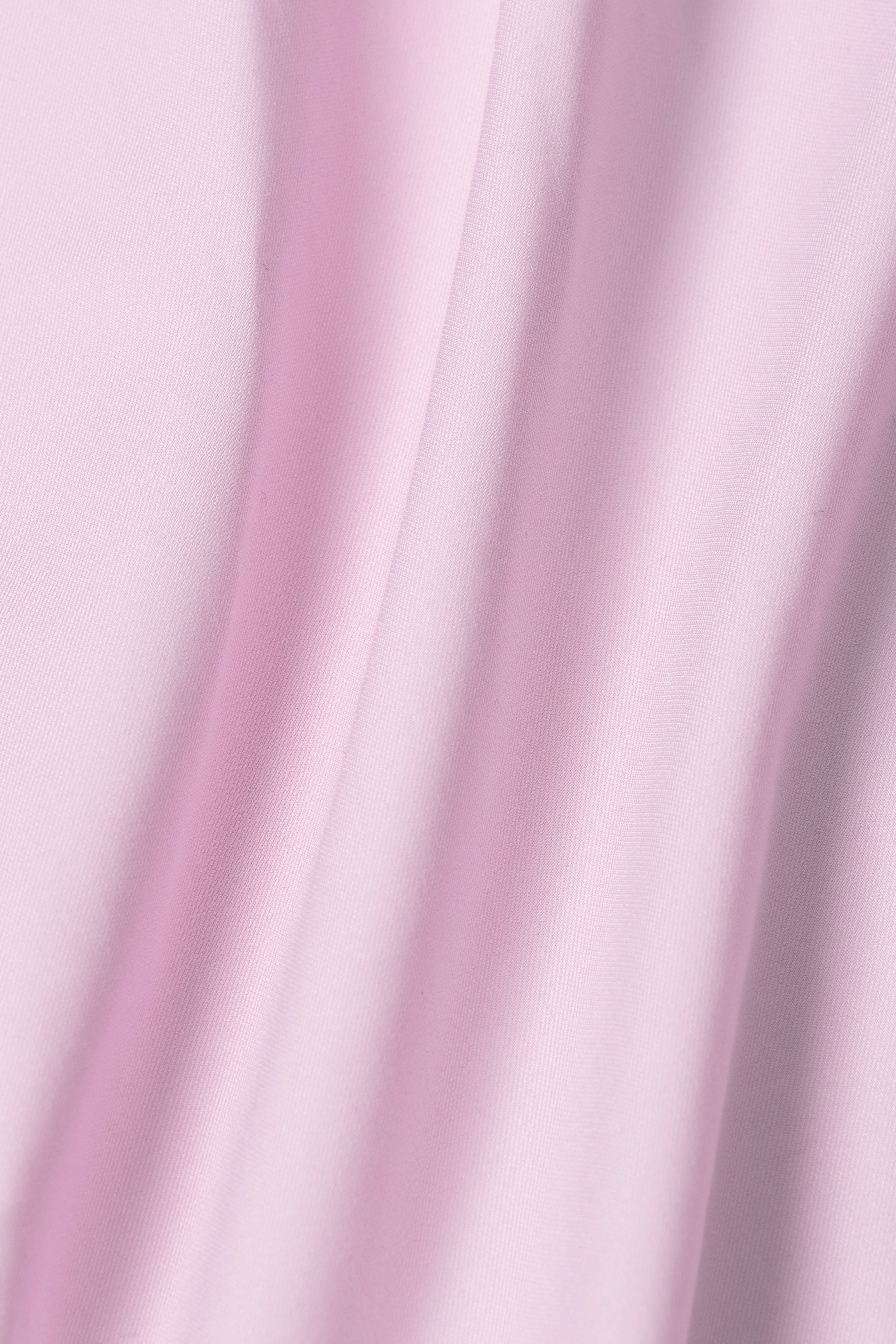 The Twillory Leader Solid // Pink shirt features soft pink fabric with gentle folds, 4-way stretch, and moisture-wicking tech to keep you comfortable and dry. Its pastel hue adds a delicate touch to this high-performance style.