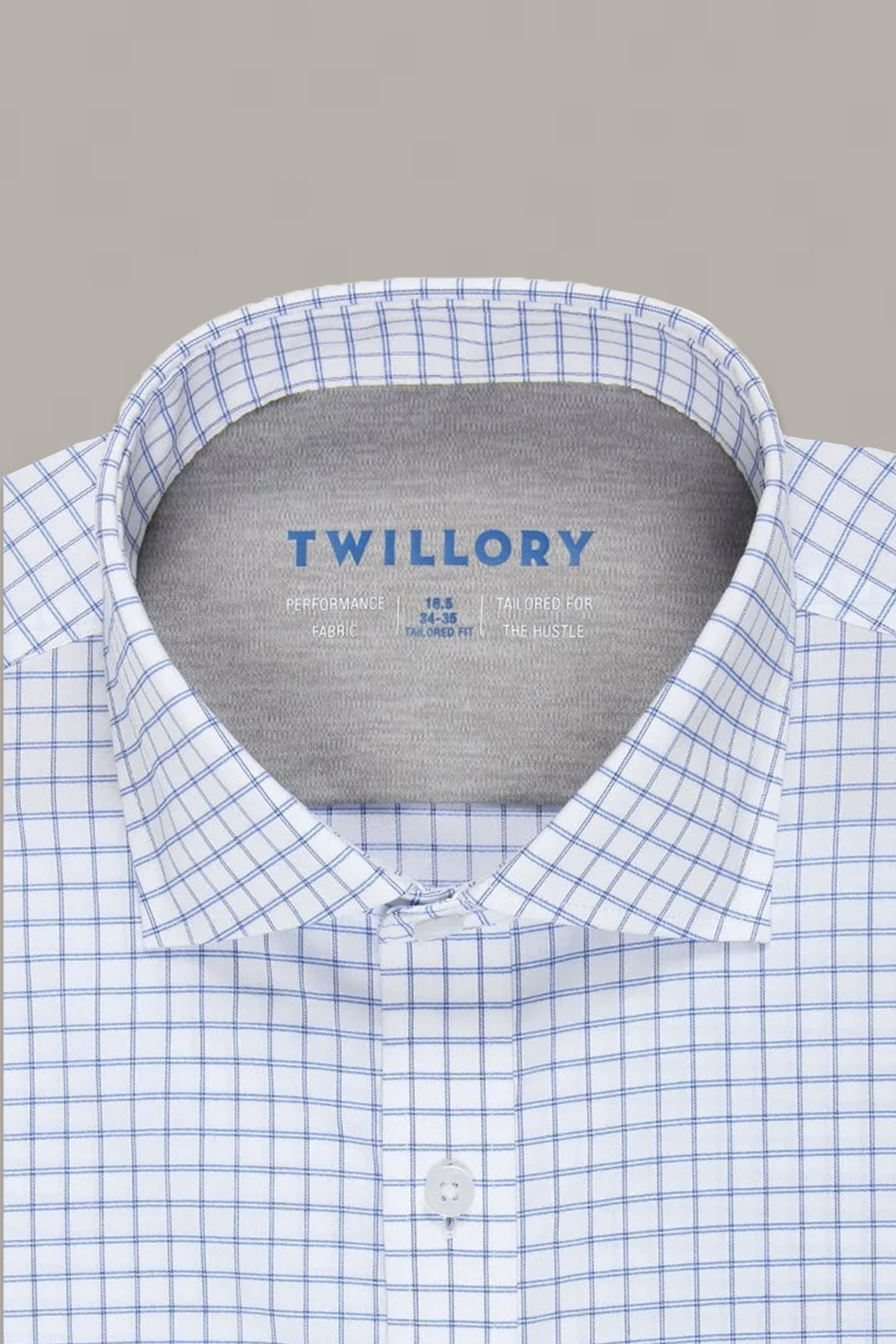 A close-up of the Twillory Leader Windowpane // Blue Performance Shirt shows a blue grid pattern on white fabric with a branded collar tag and buttoned collar.