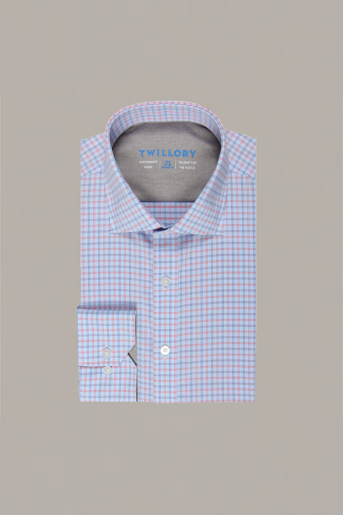 The Twillory Leader Windowpane // Red Blue is a neatly folded, long-sleeve performance shirt with a classic collar, featuring a light blue base, red and blue check pattern, and 4-way stretch comfort. Background: solid light gray.