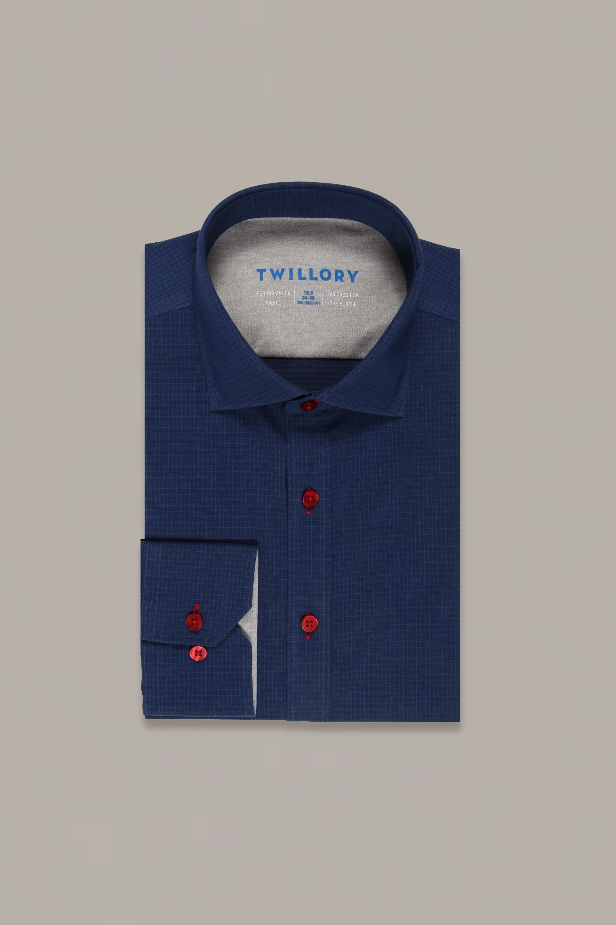 A neatly folded Twillory Leader Windowpane // Navy Red Contrast shirt features a subtle windowpane pattern and bold red buttons. The brand label is visible inside the collar, with a cuff and its red buttons shown in the lower left.