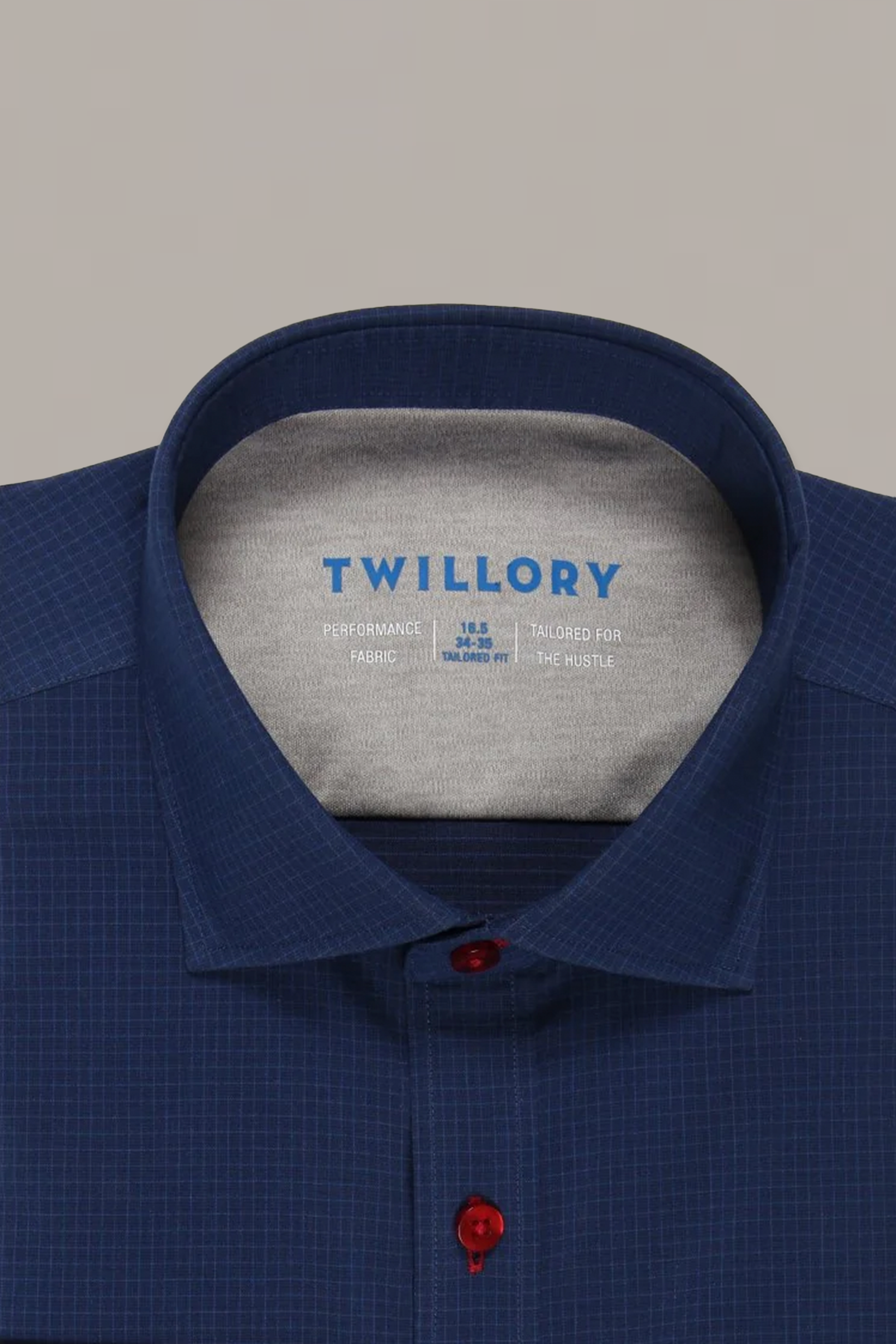 Close-up of the Twillory Leader Windowpane shirt in navy, featuring a subtle grid pattern, grey inner collar, red placket button, and 4-way stretch fabric. Brand details and size are printed inside.