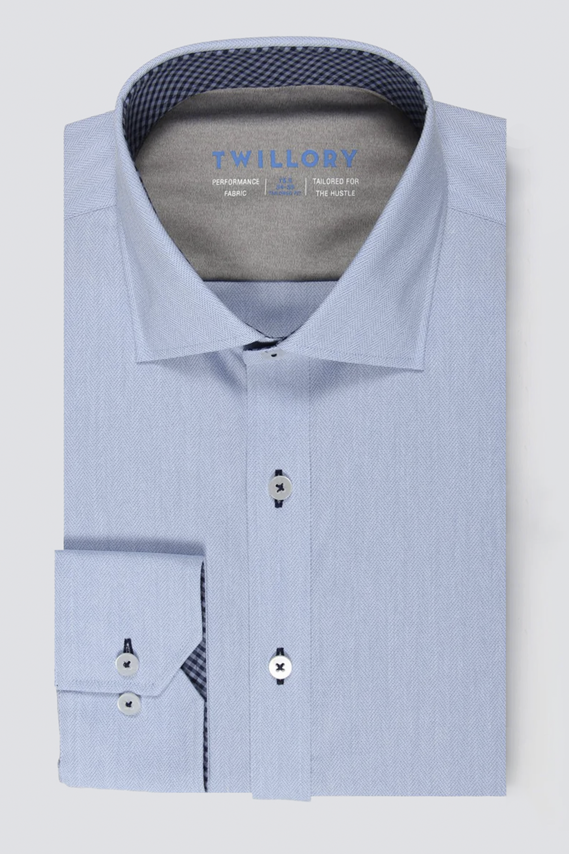 The Twillory Leader Contrast // Blue Check shirt features a blue check pattern, spread collar, 4-way stretch fabric, white buttons with dark centers, contrast trim inside the collar and cuffs, and visible Twillory branding.