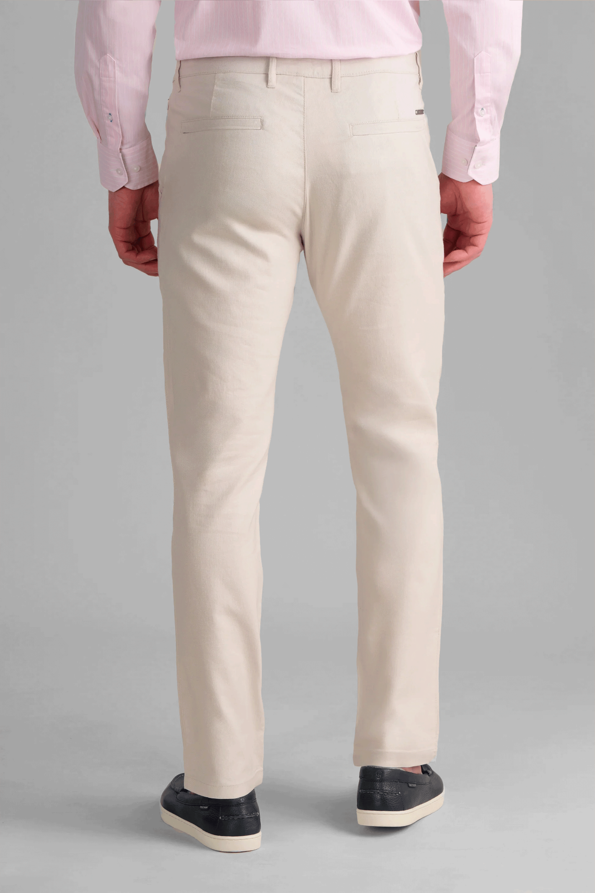 Rear view of Twillory Bone Performance Linen Pants showcasing the tailored straight-leg silhouette and clean pocket design. The performance-grade linen fabric blend provides stretch and durability, featuring integrated zippered security pockets for essential travel items.