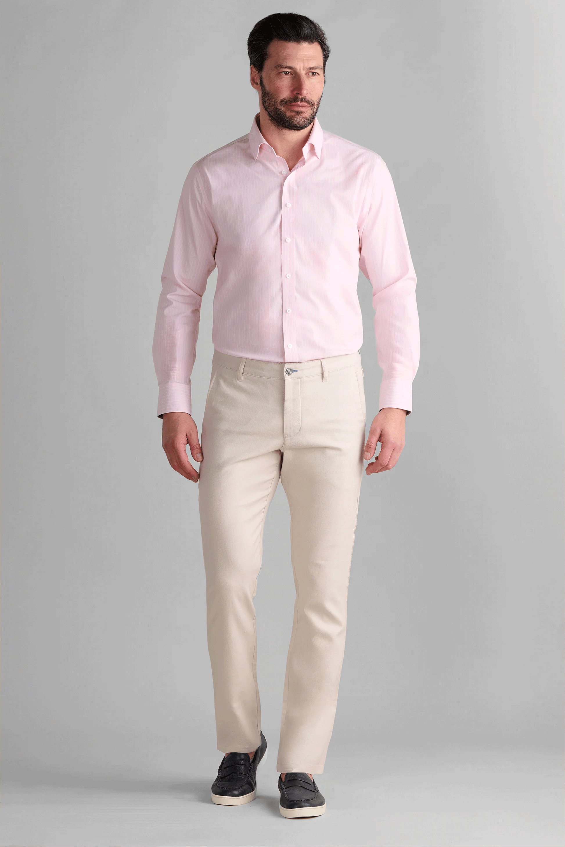 Man wearing Twillory Performance Linen Pants in Bone, styled for a modern summer look. These off-white performance trousers feature a tailored fit with a slight taper, engineered with wrinkle-resist technology and a structured flat-front to maintain a crisp appearance all day.