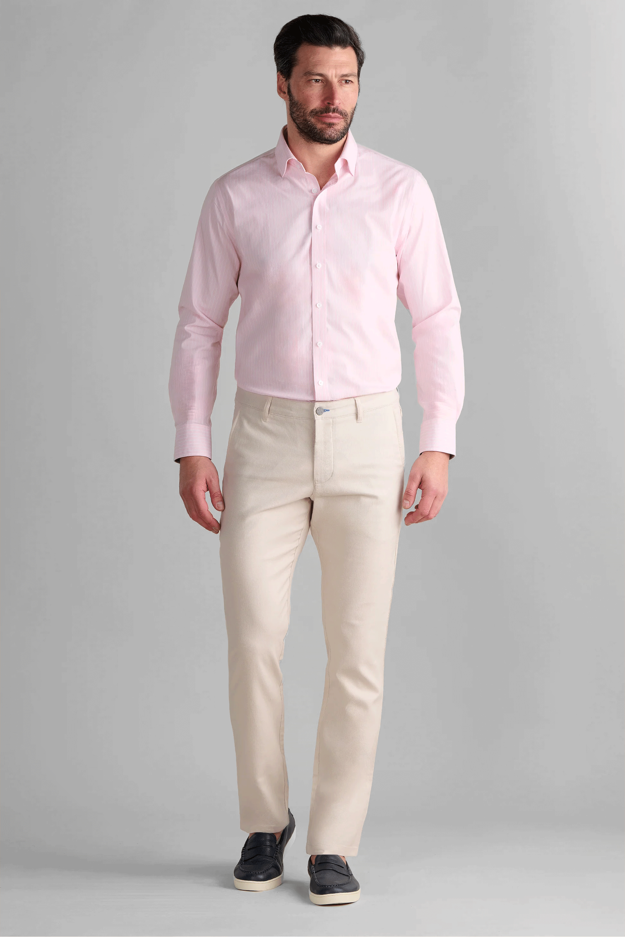 Man wearing Twillory Performance Linen Pants in Bone, styled for a modern summer look. These off-white performance trousers feature a tailored fit with a slight taper, engineered with wrinkle-resist technology and a structured flat-front to maintain a crisp appearance all day.