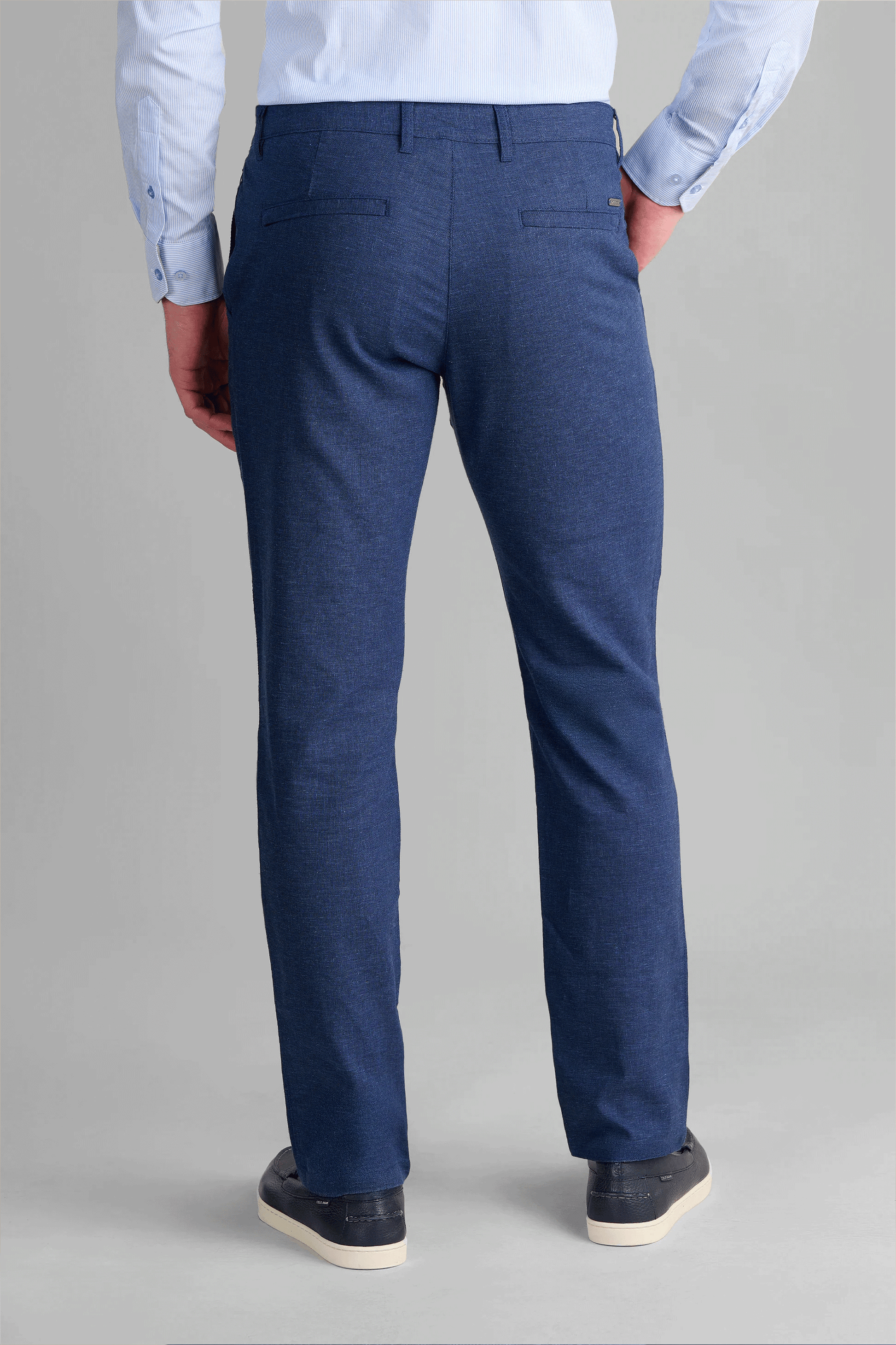 Rear view of Twillory Blue Performance Linen Pants showing the structured fit and hidden zippered travel pockets. The high-performance linen-blend fabric maintains a crisp, wrinkle-free appearance throughout the day, featuring a slight taper and clean silhouette for professional travel.