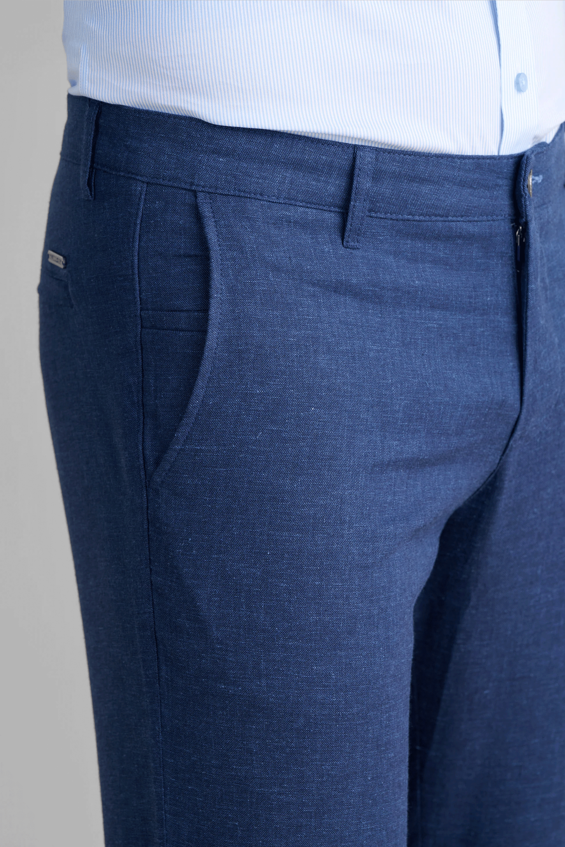 Close-up detail of Twillory Performance Linen fabric in Blue, showcasing the textured linen weave combined with performance tech. Visible features include the shirt-gripping waistband and durable stitching of the moisture-wicking, 4-way stretch material designed for non-iron convenience.