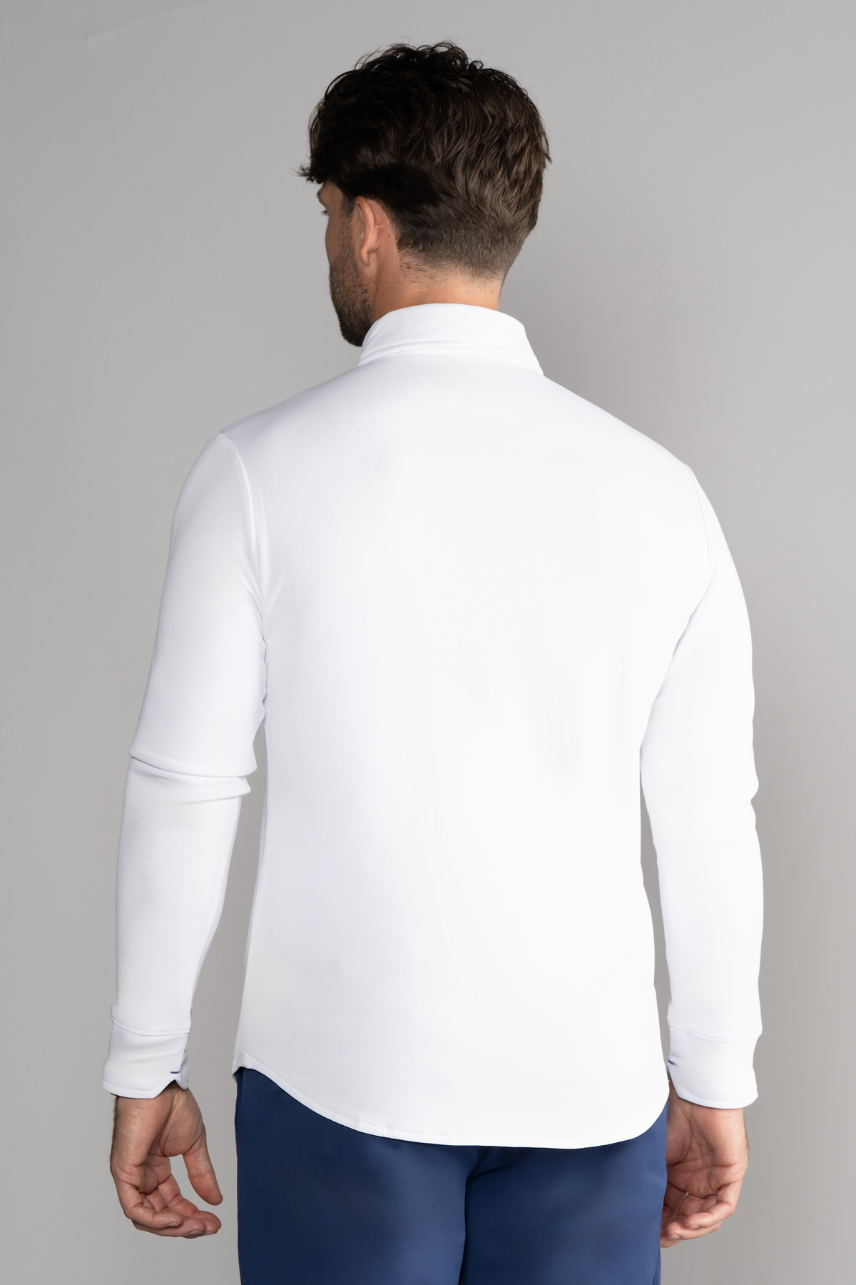 A man wears a crisp white Long Sleeve Button Down Polo Solid from Twillory.