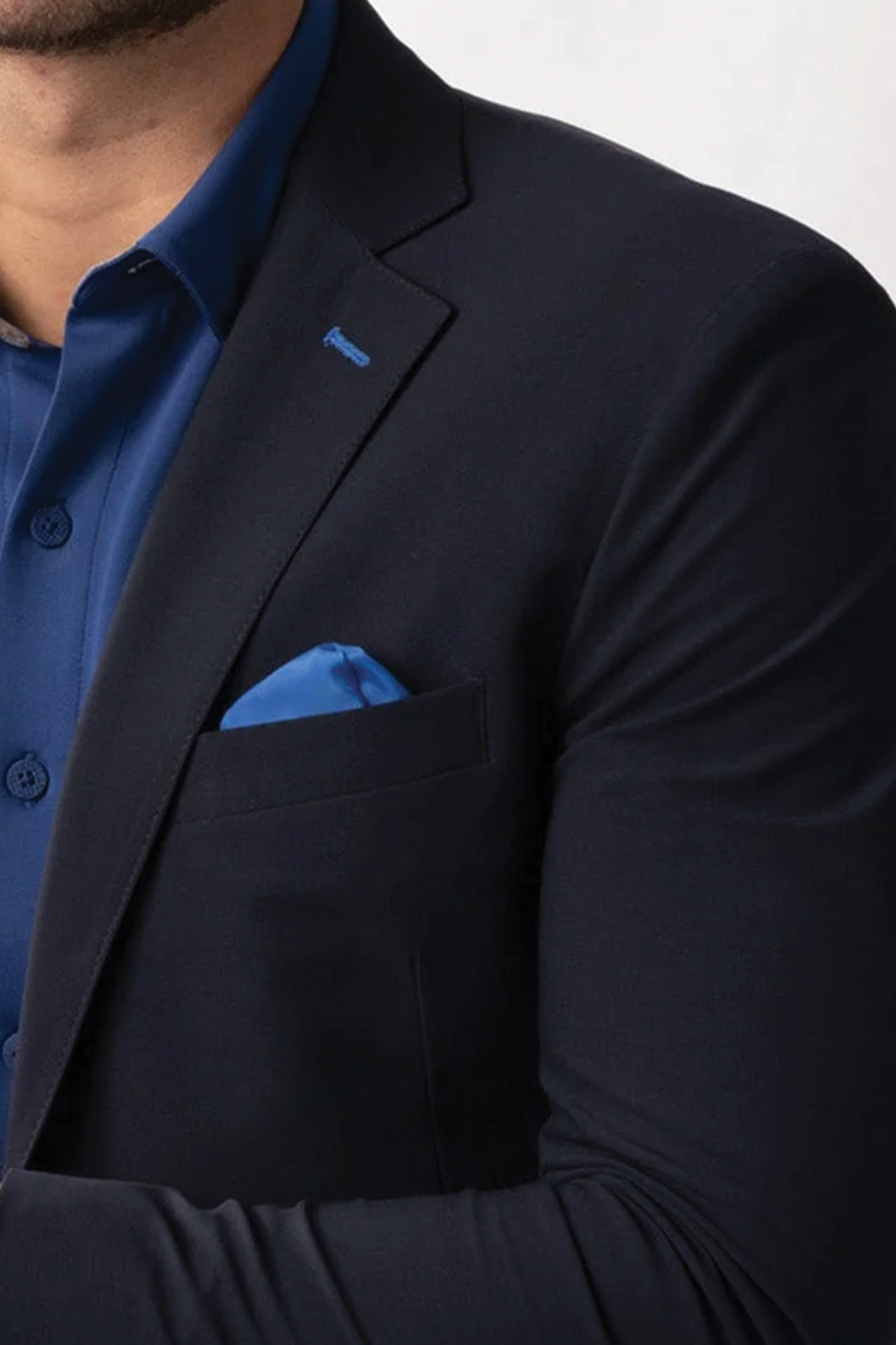 Close-up of a man wearing the Twillory Performance Blazer // NAVY BLUE CONTRAST over a blue dress shirt, with a matching pocket square. Only his lower face, neck, and part of his right arm are visible.