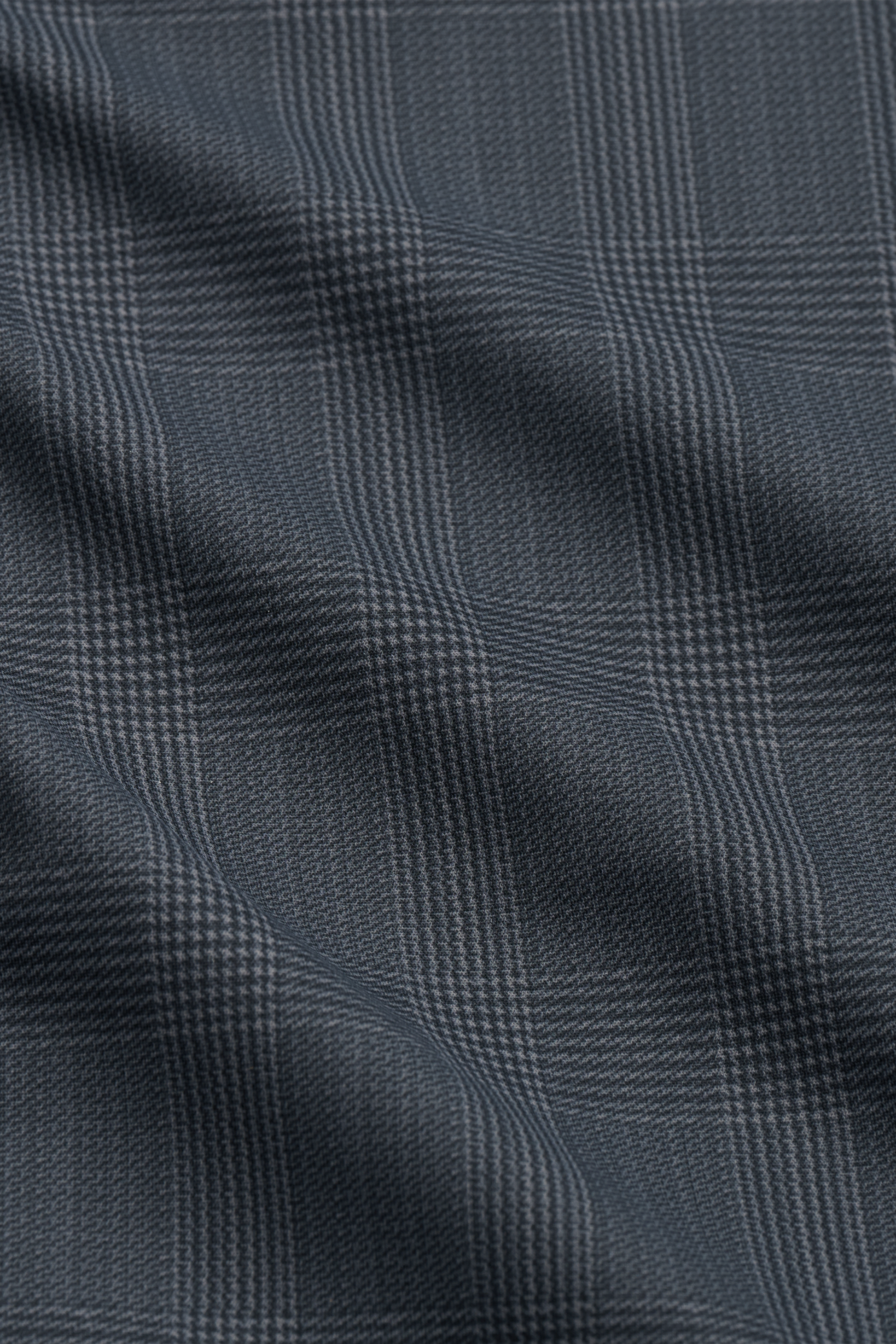 A close-up of Twillory’s Performance Blazer // Grey Prince of Wales shows fine plaid lines and 3D shoulder pads, delivering a classic, tailored look with subtle checkered pattern and stretch performance fabric.