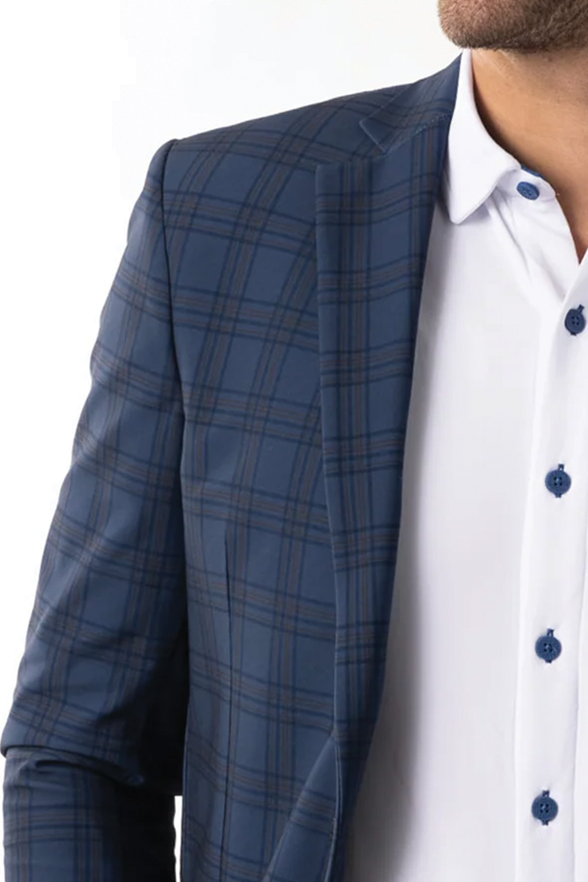 A close-up shows a man in the Twillory Performance Blazer // Blue Plaid over a white dress shirt with blue buttons, cropped to highlight the blazer's patterned fabric and details.
