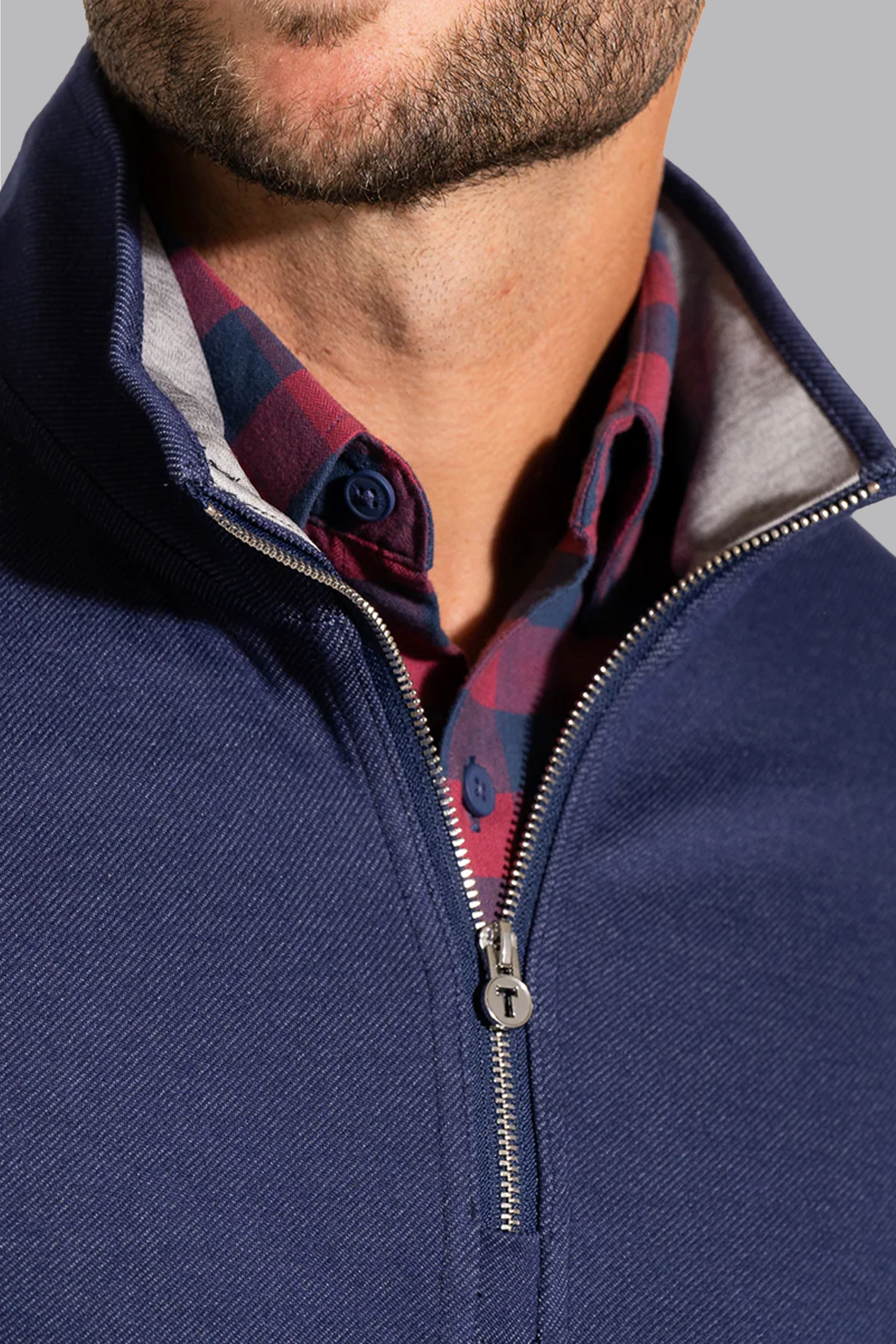 A close-up of a man's neck, featuring the Twillory Performance Quarter Zip // Denim layered over a crisp shirt.