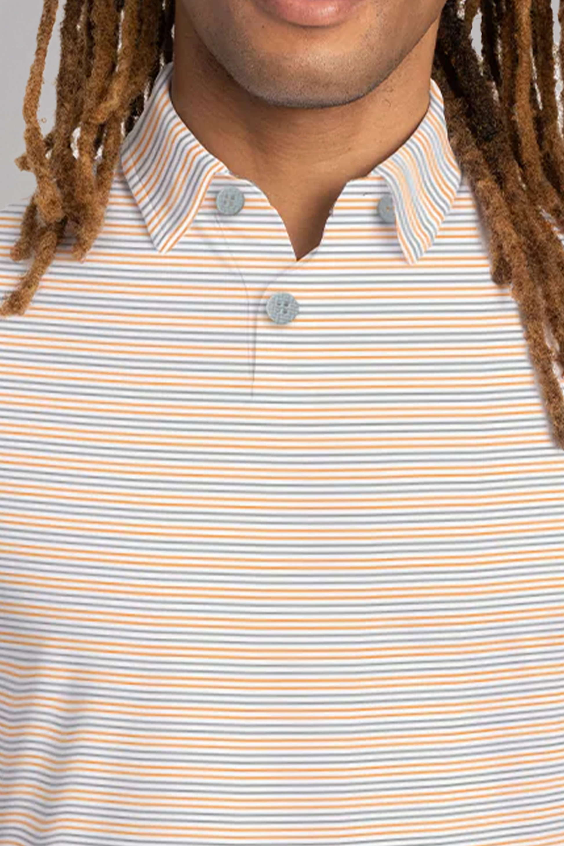 A person with long, light brown dreadlocks wears the Twillory Short Sleeve Polo Stripe in Grey Orange. The striped shirt’s moisture-wicking stretch fabric and two-button collar are visible, showing only the lower half of their face.
