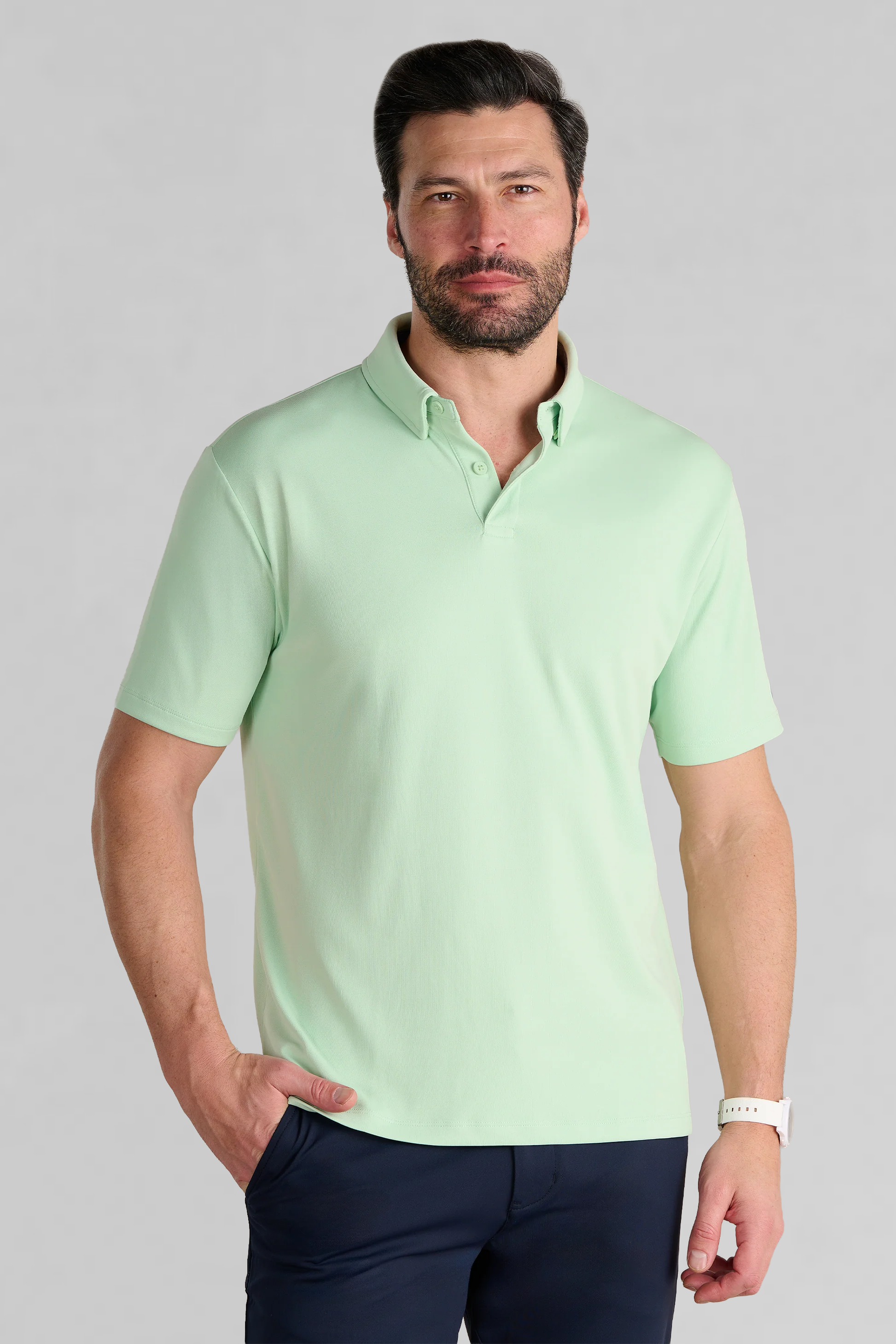 A bearded man wears the Twillory Short Sleeve Polo Solid in Pastel Green, a moisture-wicking performance shirt.