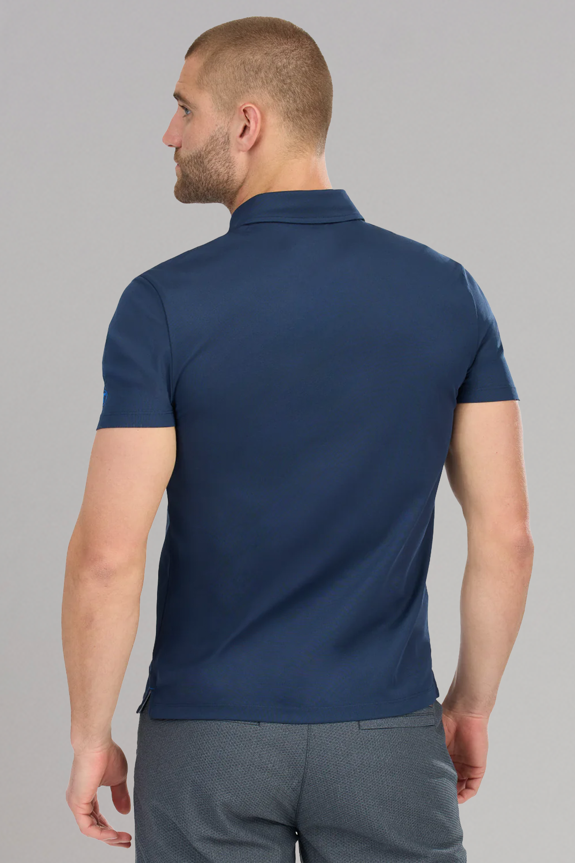 A man in a Twillory Slim Fit Pique Polo Solid in Navy, designed with moisture-wicking fabric.