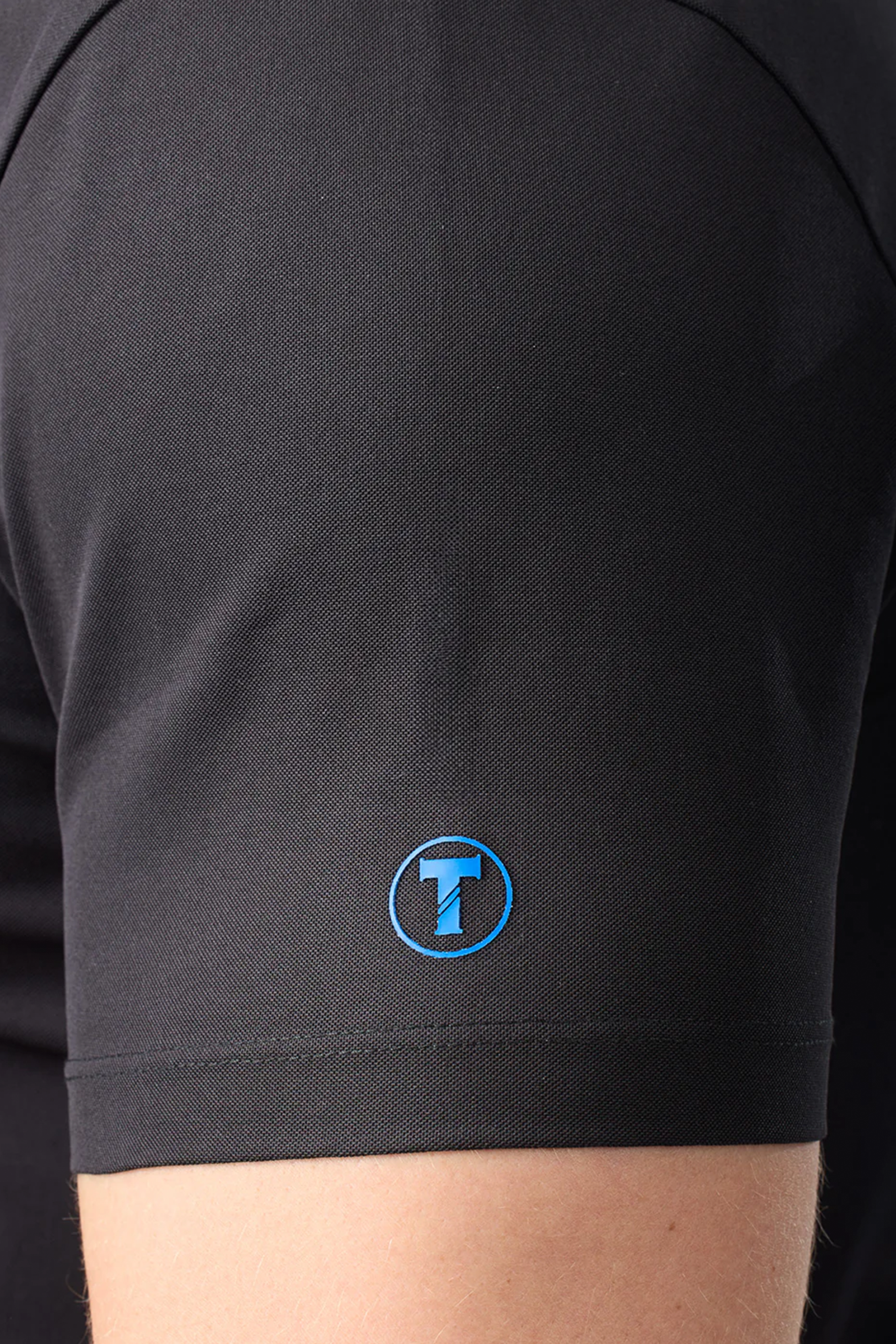 A person wearing the Twillory Slim Fit Pique Polo Solid in black.