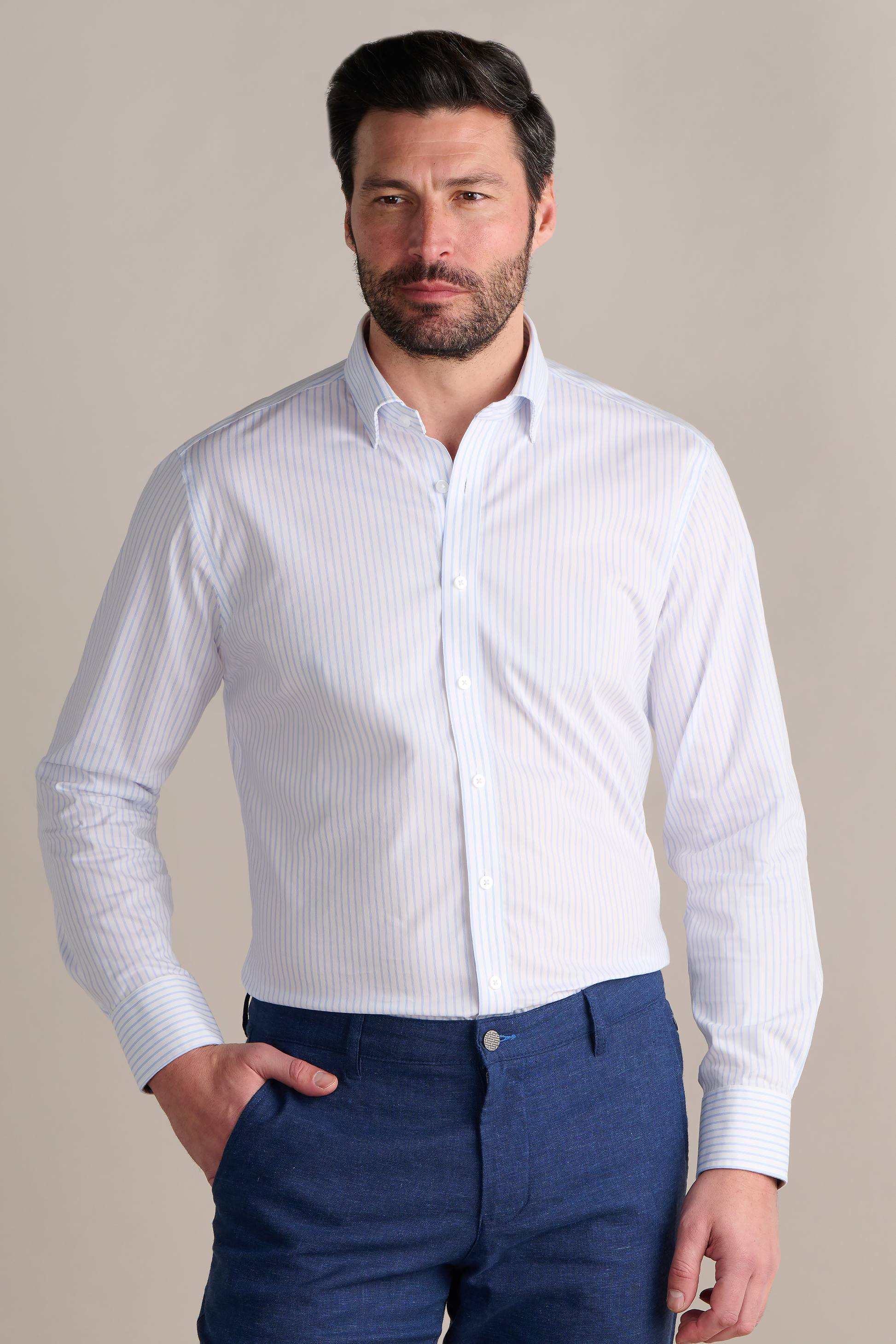 A man poses for a photo wearing the Twillory Leader Stripe // Thick White performance shirt, highlighting its 4-way stretch design for superior comfort and flexibility.