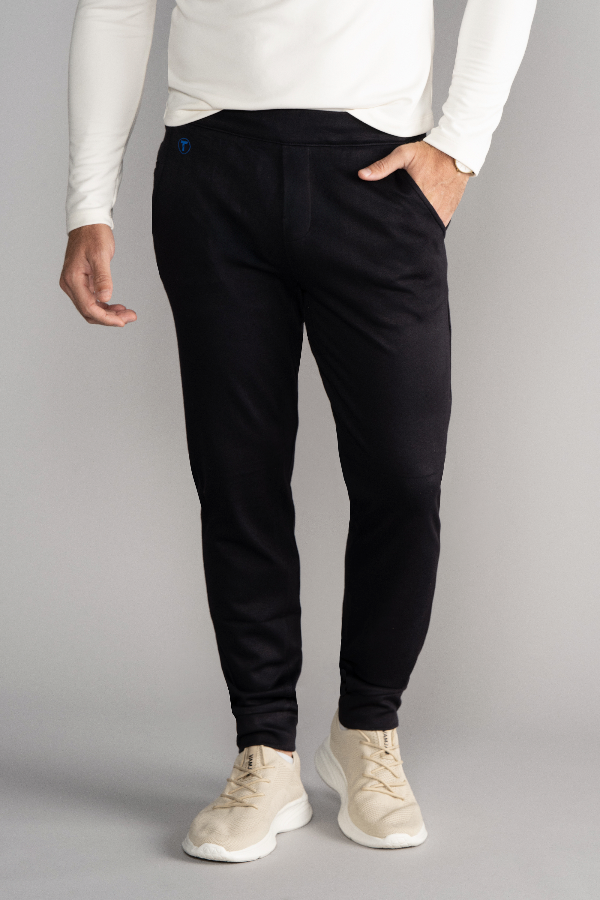 Wearing Twillory’s Athlounger Jogger—comfort fabric pants with a side-zip pocket—a person stands against a light gray background, hand in pocket. Only the lower torso and legs are visible.