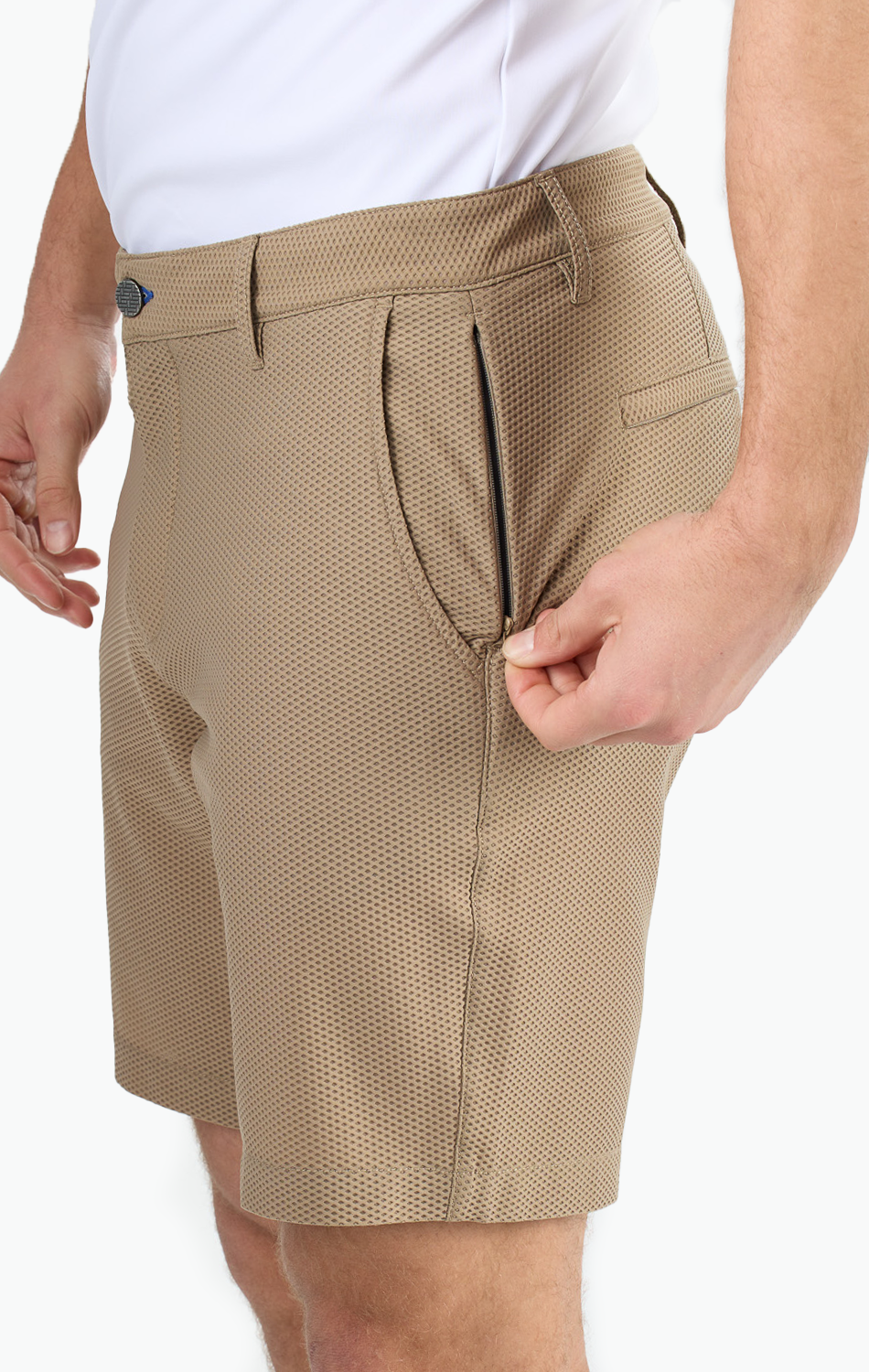 Man adjusting pocket zipper on beige textured shorts, wearing a white shirt.