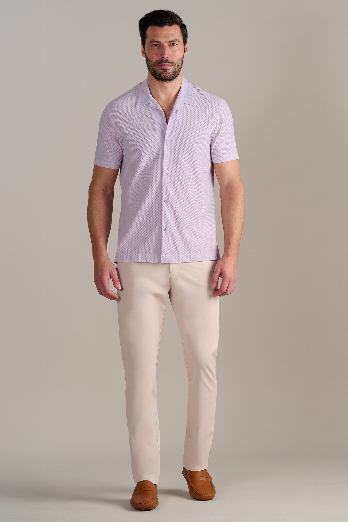 A man with short dark hair and a beard stands facing forward against a plain background, wearing the Twillory AIR Resort Shirt Solid in Lilac. The shirt features cooling AIR fabric and is machine washable. He has a neutral expression.