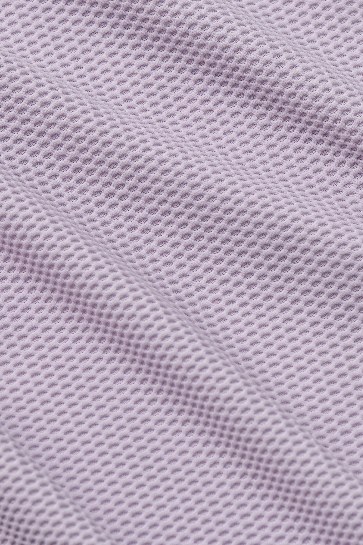Close-up of Twillory's AIR Zip Polo Solid in Lilac, featuring soft, light purple 360° Airflow Fabric with a textured waffle-like pattern for a flexible, three-dimensional look and hyper-breathable comfort.
