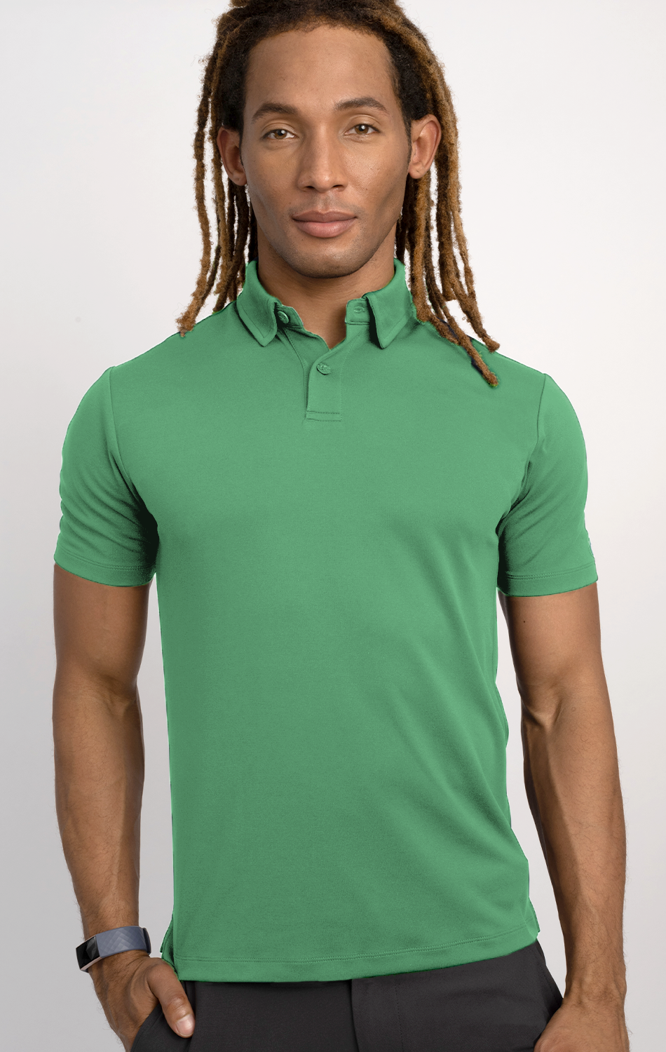 A person with long, light brown dreadlocks models the Twillory Short Sleeve Polo Solid // Mint, paired with black pants and a black wristband, standing forward-facing with a neutral expression against a plain light background.