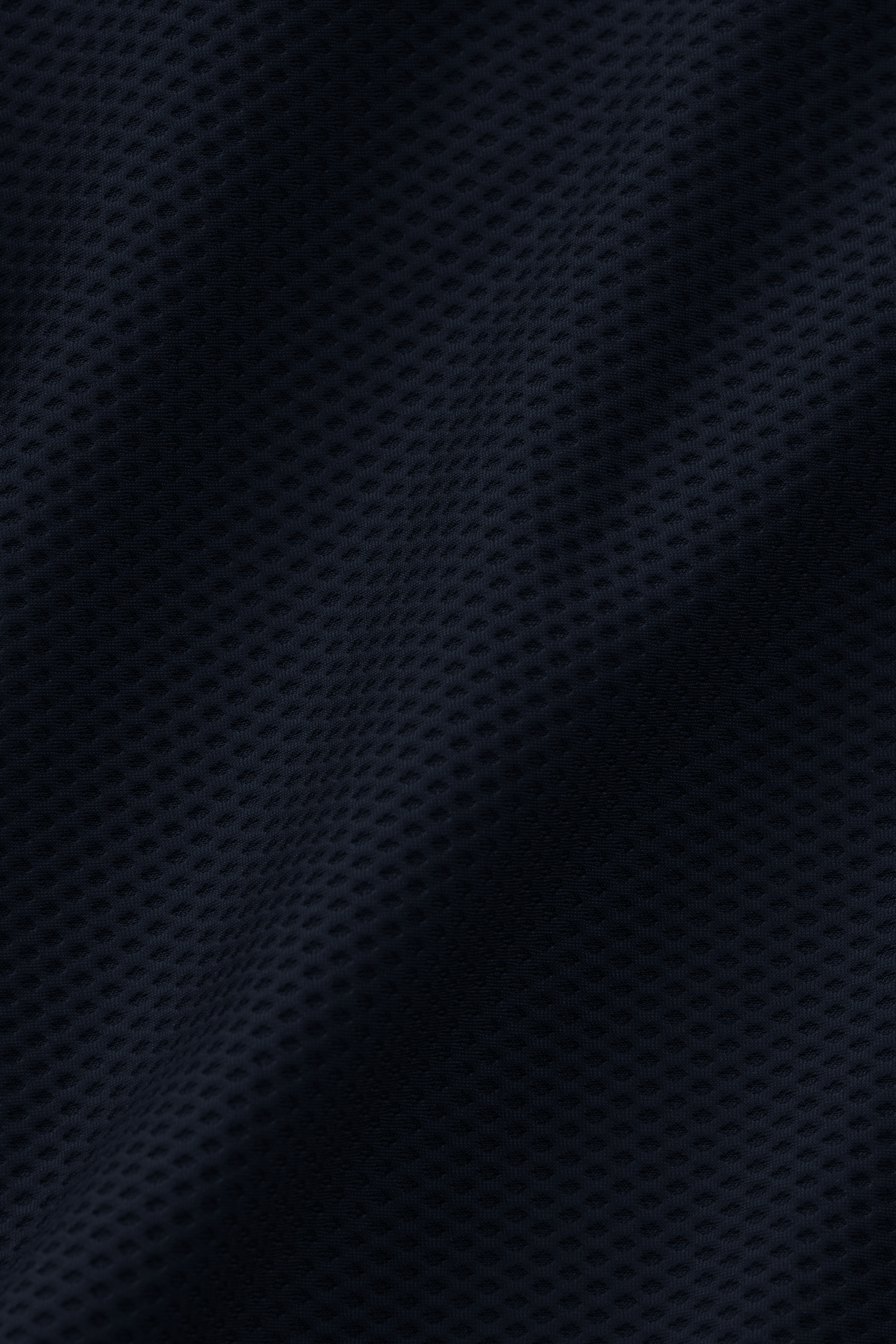 Close-up of Twillory's AIR Double Breasted Blazer in Navy, featuring dark blue mesh performance fabric with a subtle wave pattern and perforated texture for breathability—perfect for lightweight, athletic-inspired style.