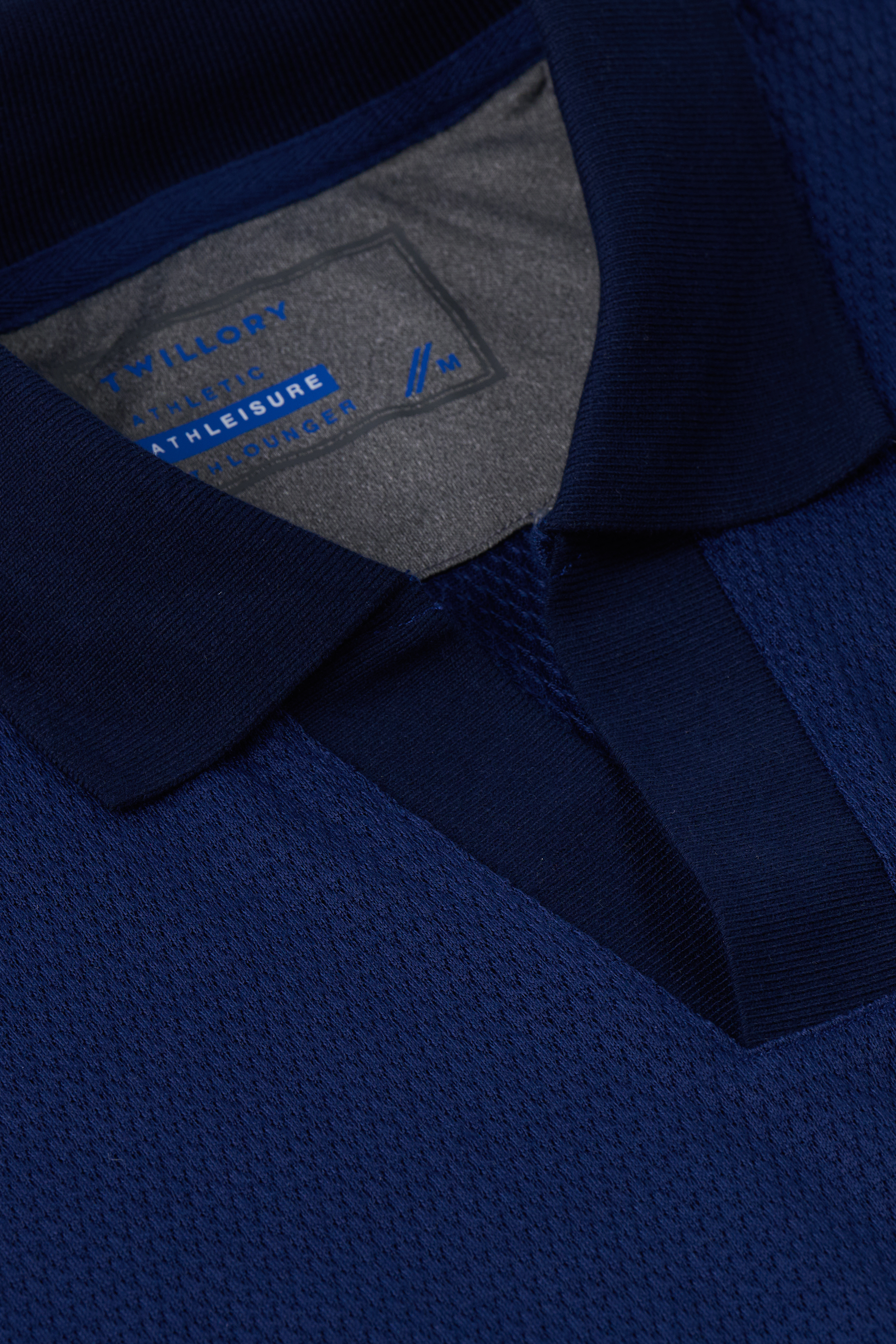 Close-up of the collar and neckline on the Twillory Long Sleeve Sweater Polo Solid in Navy. The soft, ribbed Johnny collar forms a V-neck above a partially open placket, with subtle mesh-like texture throughout.