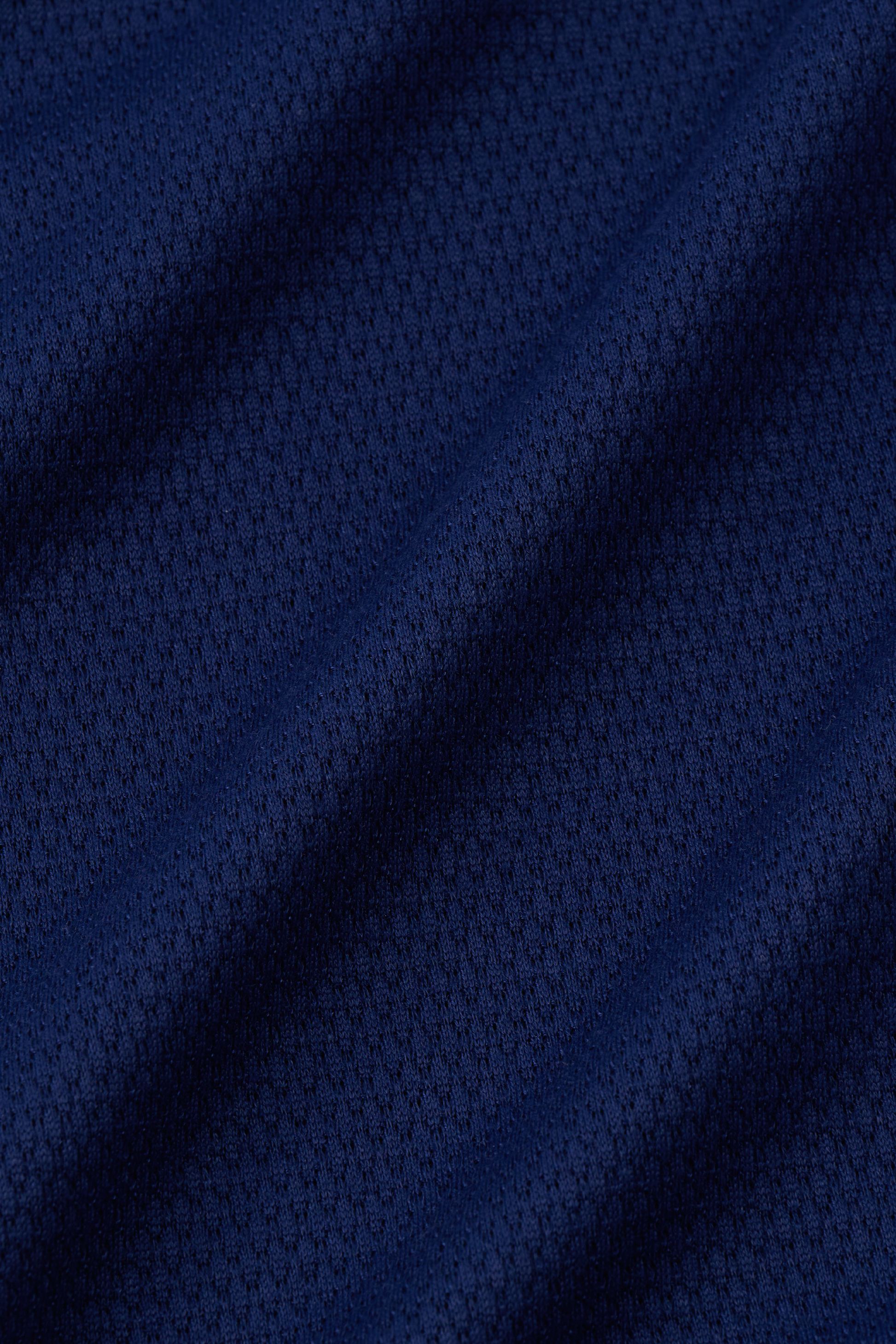 Close-up of the Twillory Long Sleeve Sweater Polo Solid in Navy: dark blue textured fabric with a subtle diamond pattern and soft folds, suggesting breathable, wrinkle-free material—ideal for modern knit polo styles.