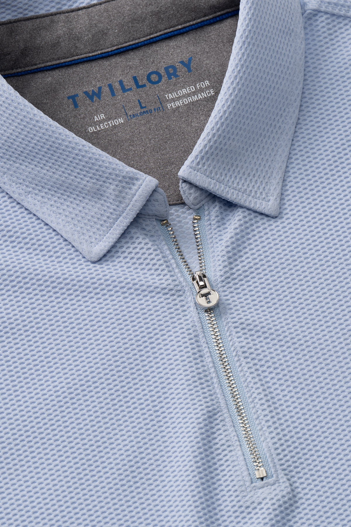 Close-up of the Twillory AIR Zip Polo Solid in Powder Blue, featuring 360° Airflow Fabric, a silver zipper, structured collar, and subtle waffle texture for breathable all-day comfort.