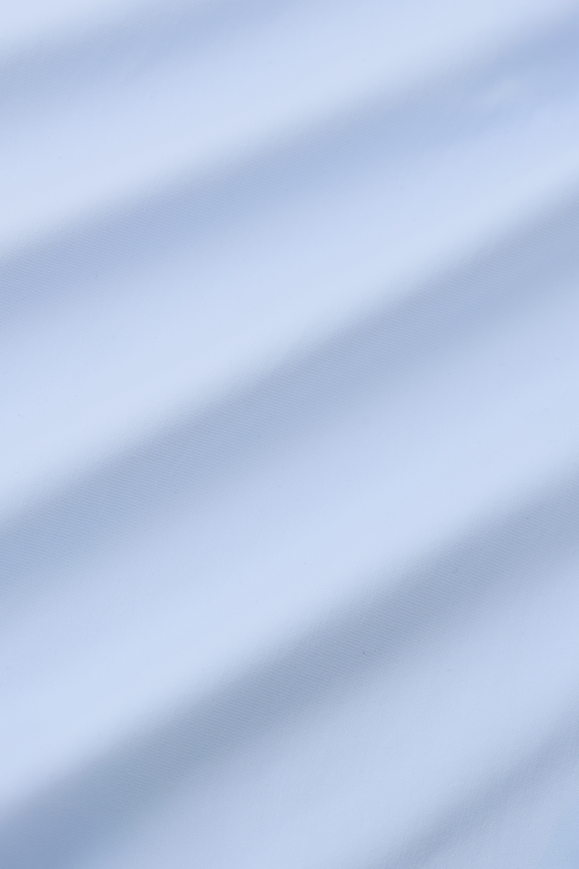 Close-up of Twillory's Event Polo Solid in Powder Blue—smooth, wrinkle-free performance stretch fabric with soft diagonal folds and shadows, evoking the premium look and feel of a dress shirt.
