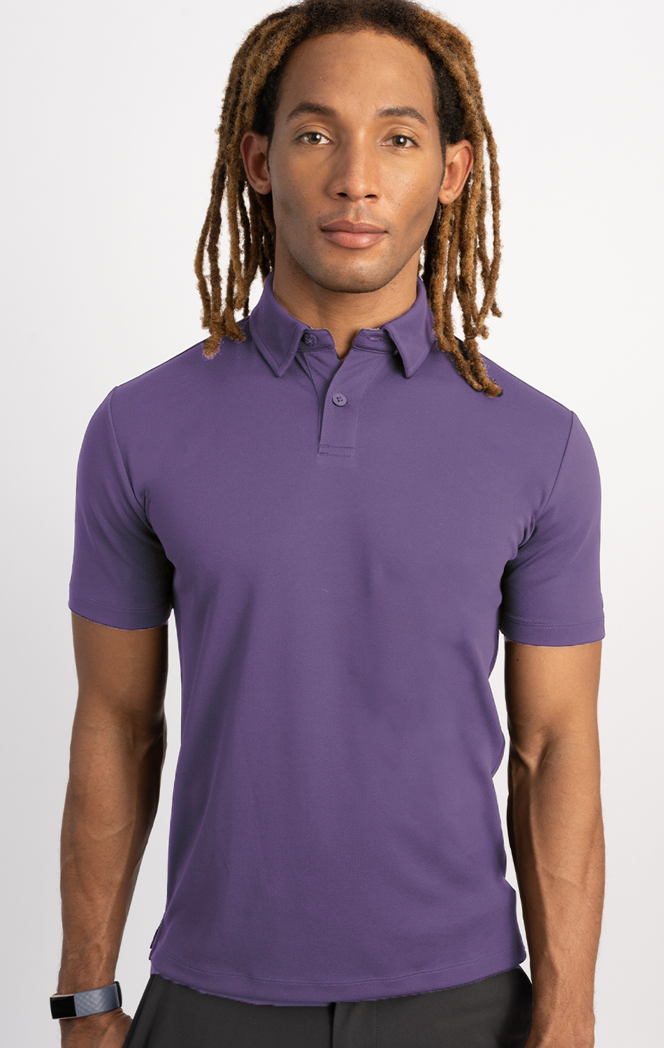 A man wearing the Twillory Short Sleeve Polo Solid in purple, featuring a tailored fit and moisture-wicking fabric.