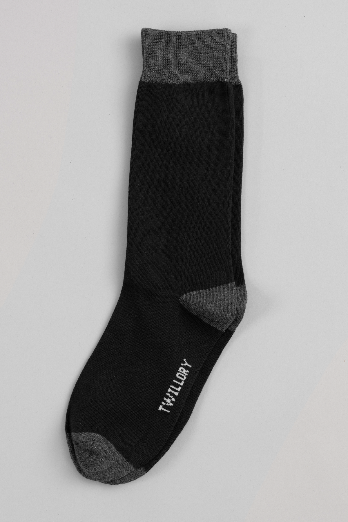 A single Twillory "Black As Night" sock with gray accents on the cuff, heel, and toe lies flat on a light gray background. "Twillory" is printed in white near the toe—ideal for enhancing your favorite sock collection.