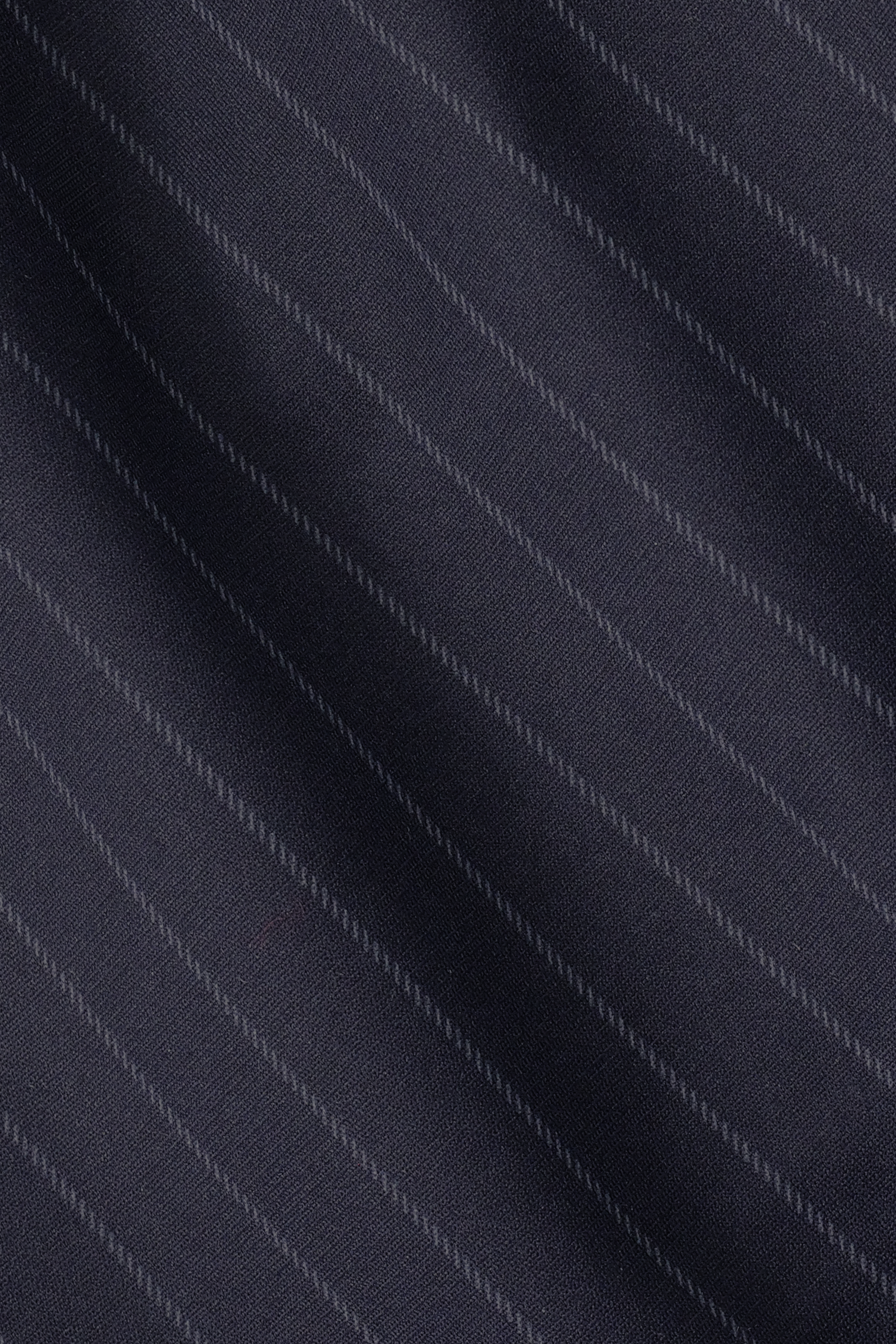 Close-up of Twillory Performance Pants // Navy Stripe shows dark navy blue fabric with fine diagonal light gray pinstripes. The smooth, gently folded material suggests softness and subtle sheen—perfect for non-iron, stretch travel pants.