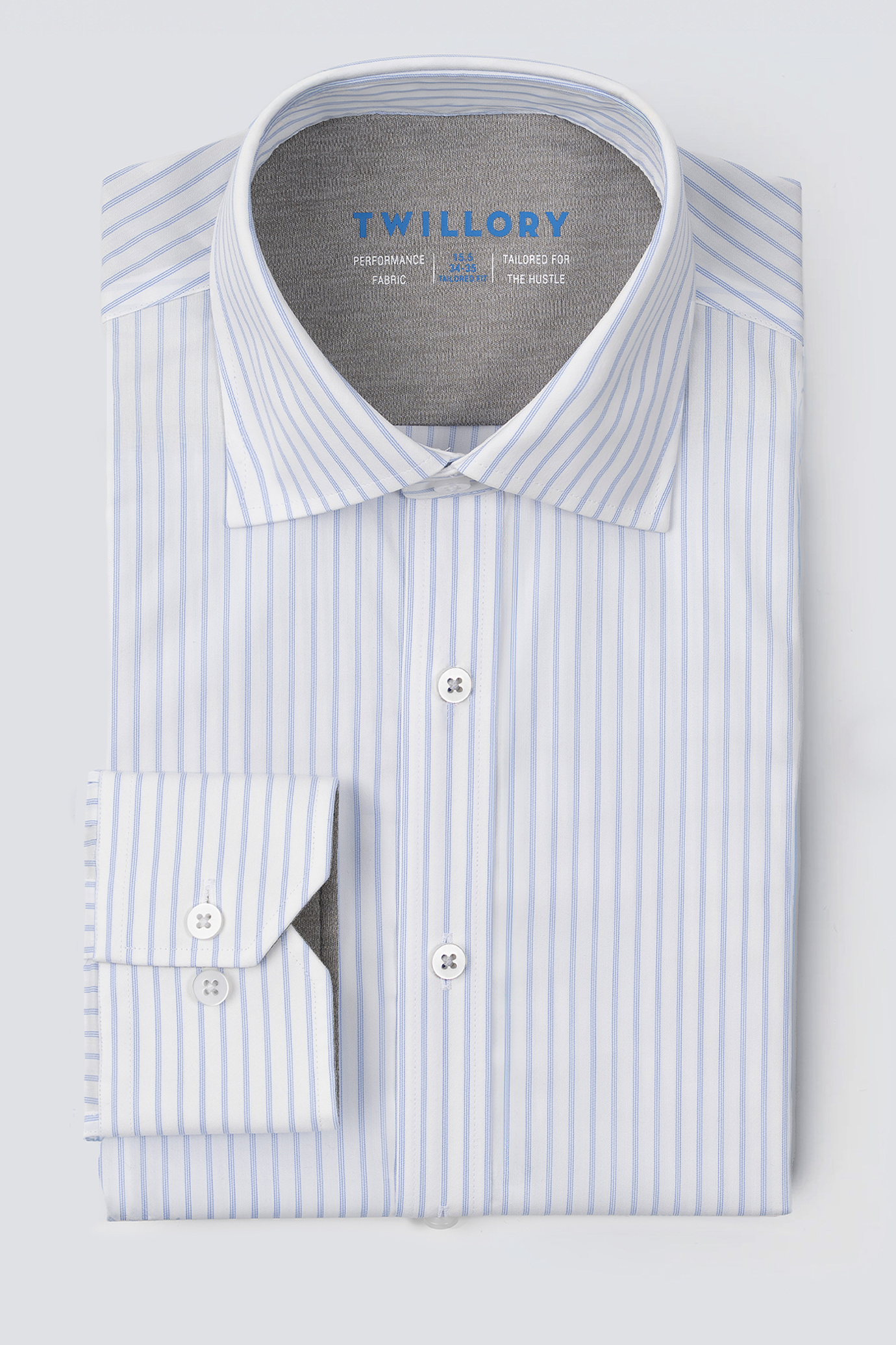 The Twillory Leader Stripe // Thick White is a long-sleeve performance shirt with light blue vertical stripes on white, a classic collar, white buttons, single cuff, and "Twillory" printed in blue inside the collar.