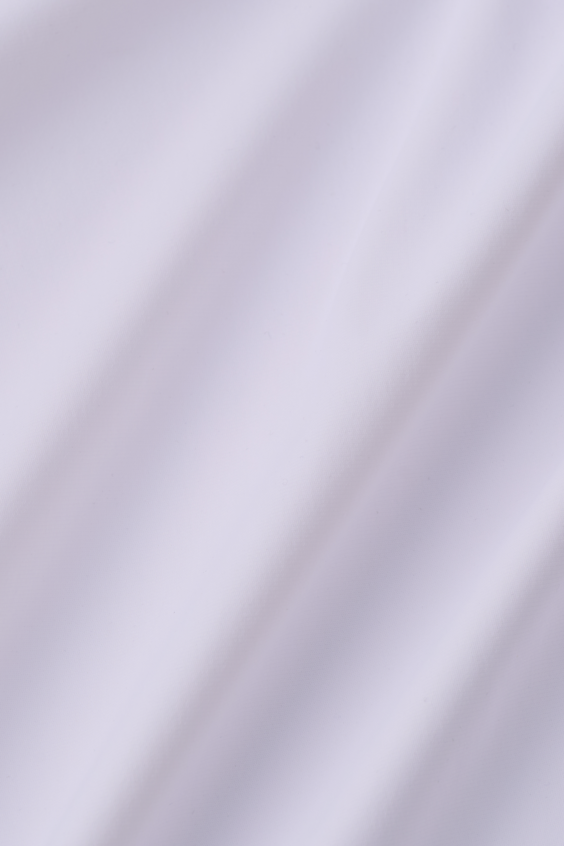 A close-up of the Twillory Event Polo Solid in White shows its smooth, wrinkle-free fabric with soft diagonal folds and a silky sheen, highlighting the polo’s seamless softness and clean, pure finish.