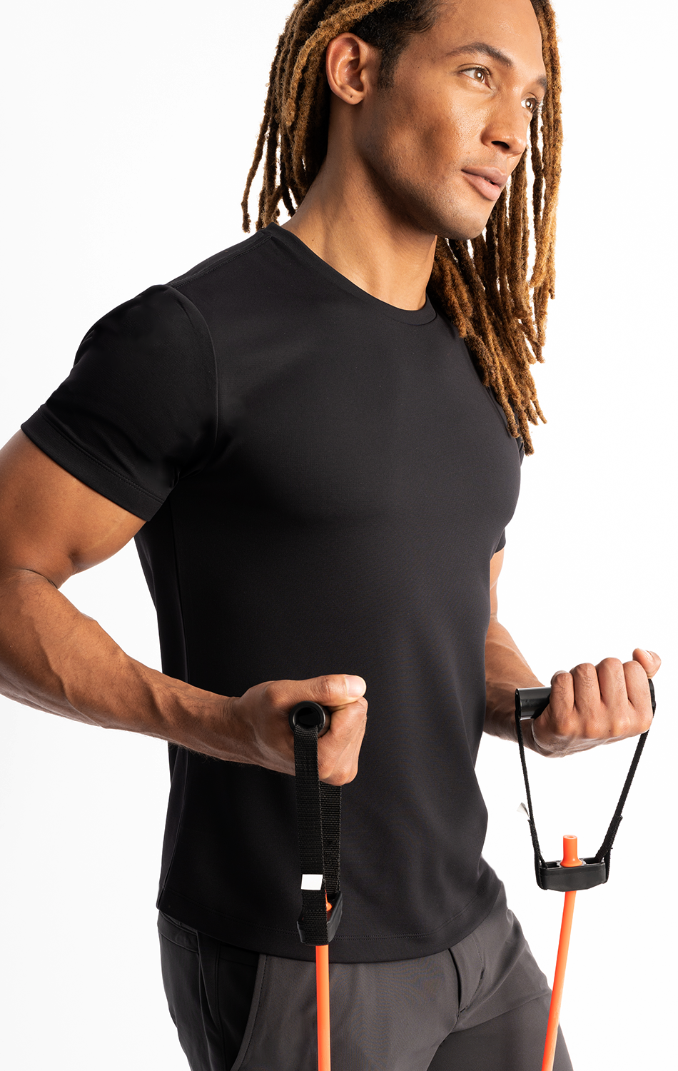 Man exercising with resistance bands wearing a black t-shirt and dreadlocks.