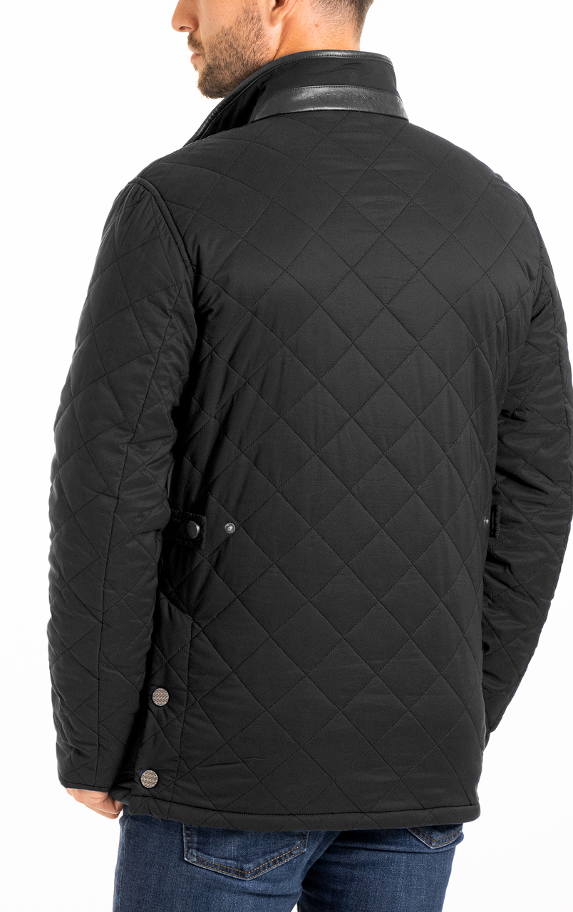 Man wearing a black quilted jacket with button details, viewed from the back, with dark jeans.