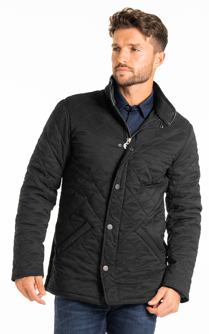 Man wearing a stylish black quilted jacket with a zipper and button closure, paired with a navy shirt.